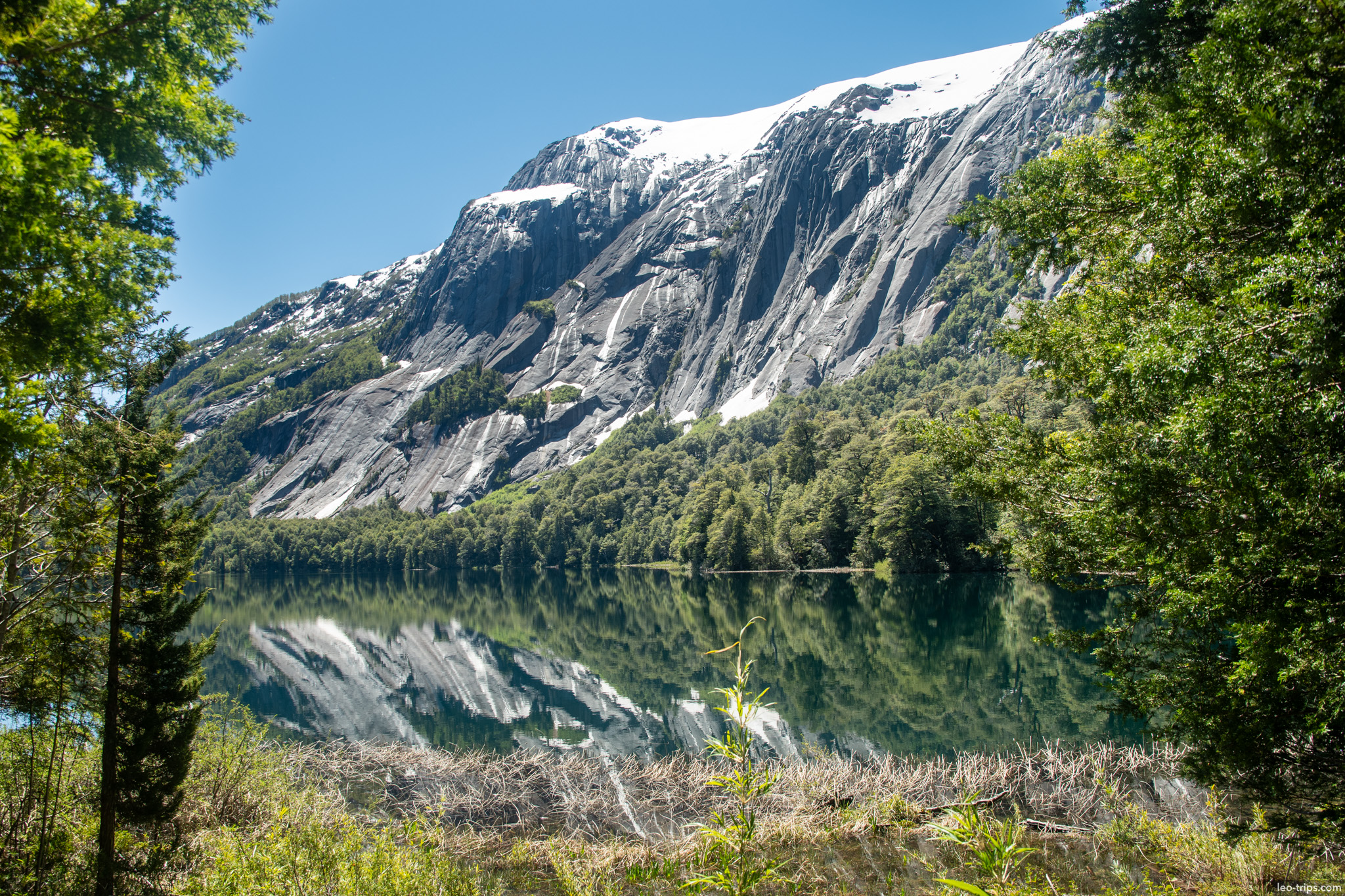 granite cliff reflected in lake puerto blest