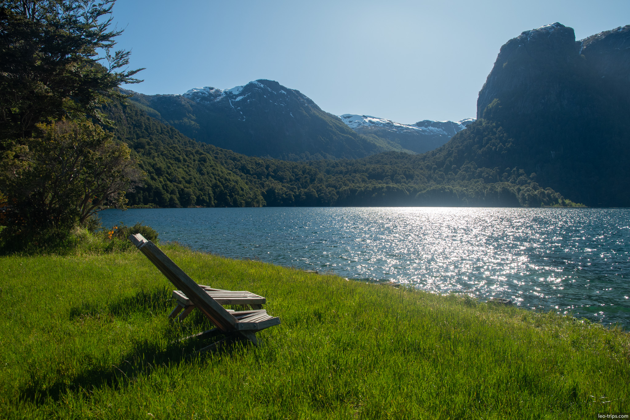 wooden bench facing sunlit lake puerto blest