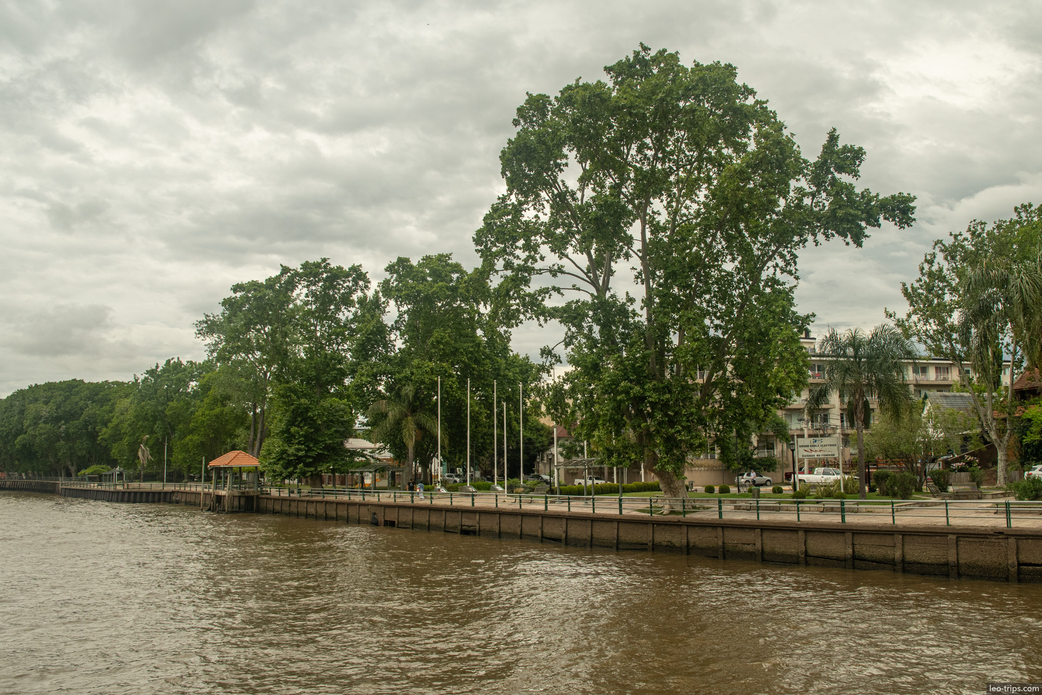 riverside promenade tall trees flags tigre