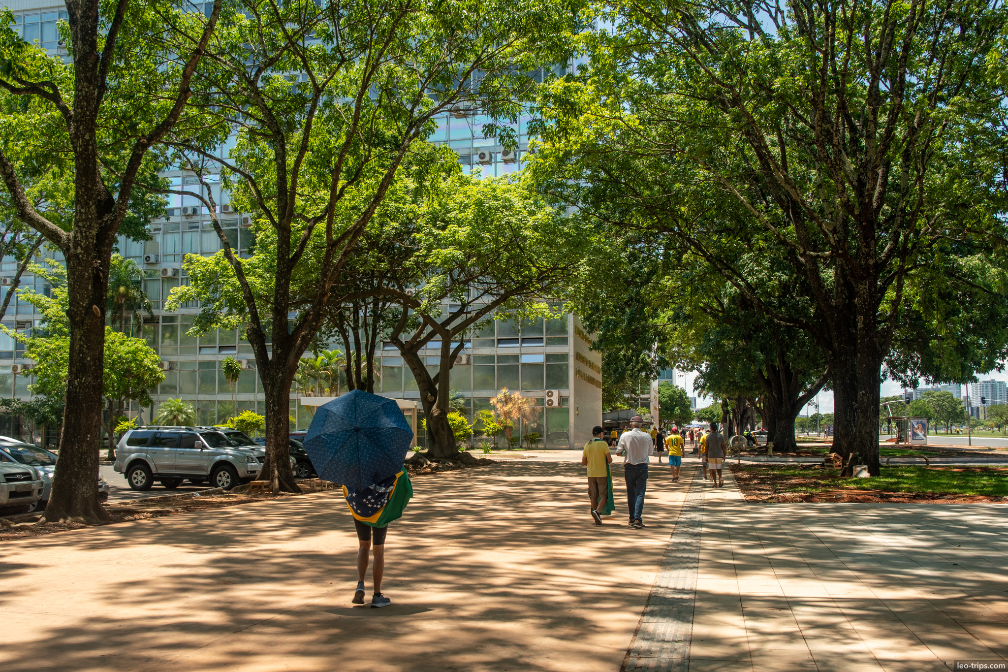 shaded sidewalk people umbrella brazilian flag brasilia