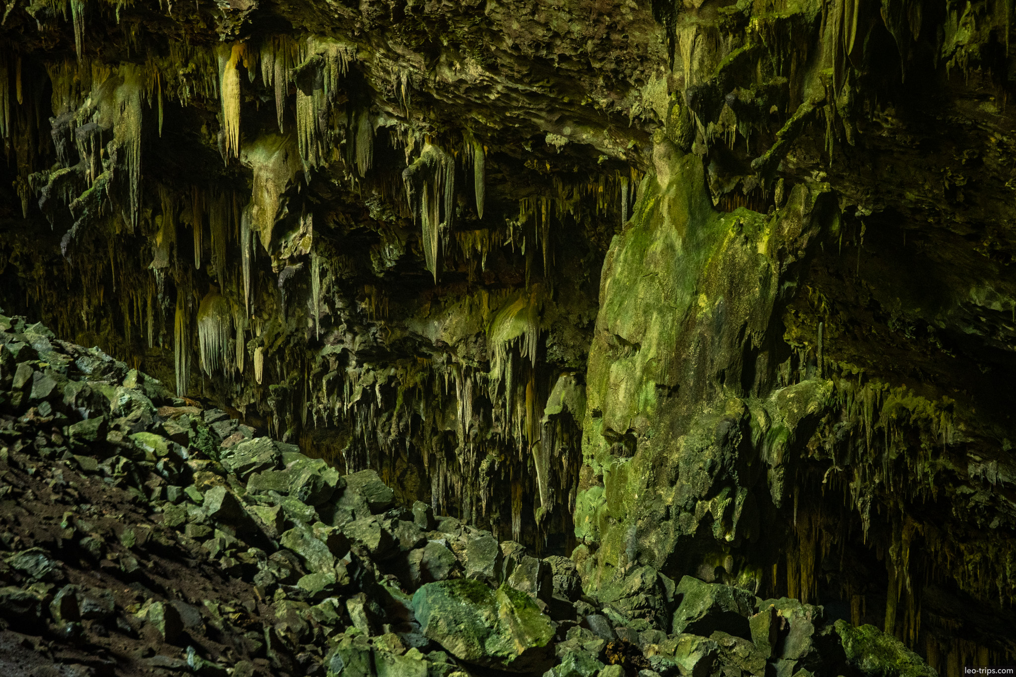 stalactites and mossy rock column over boulder slope gruta do lago azul gruta do lago azul