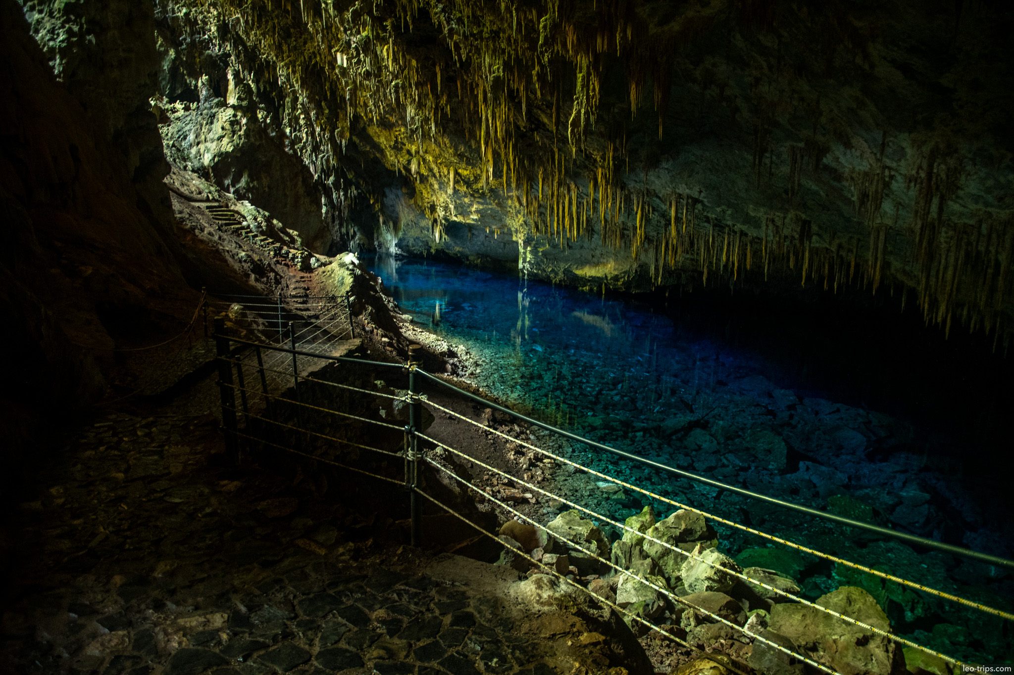 walkway with railings along blue lake gruta do lago azul gruta do lago azul