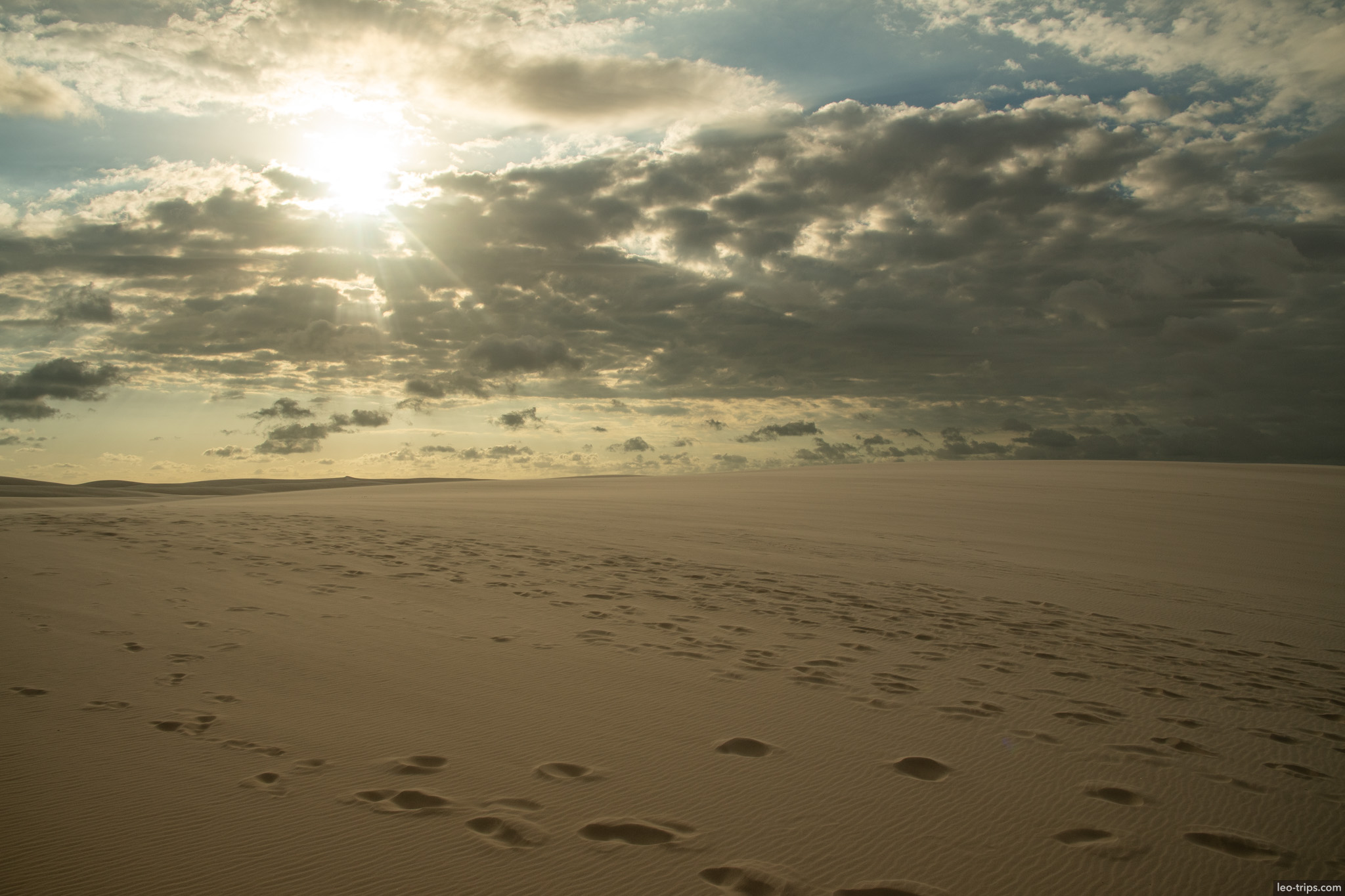 footprints sand dune sunbeams cloudy sky lencois lencois maranhenses