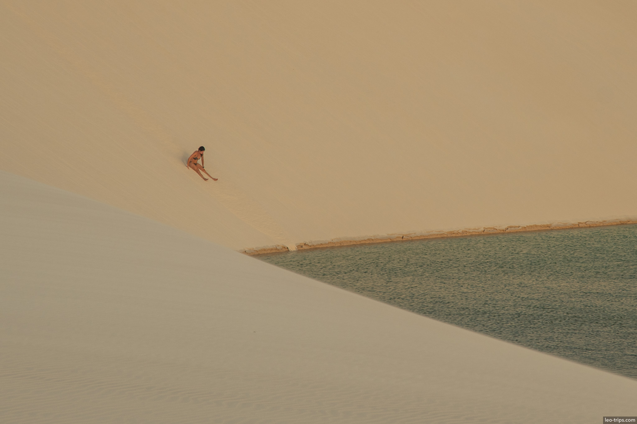 lone figure dune edge lagoon lencois lencois maranhenses