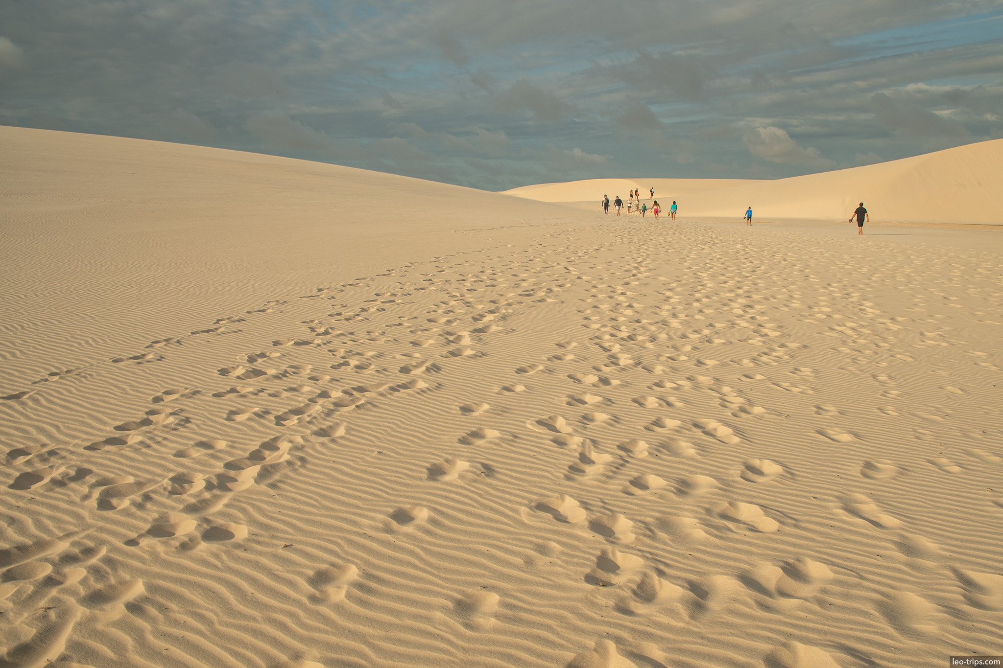 tourists hiking up sand dune sunset lencois lencois maranhenses