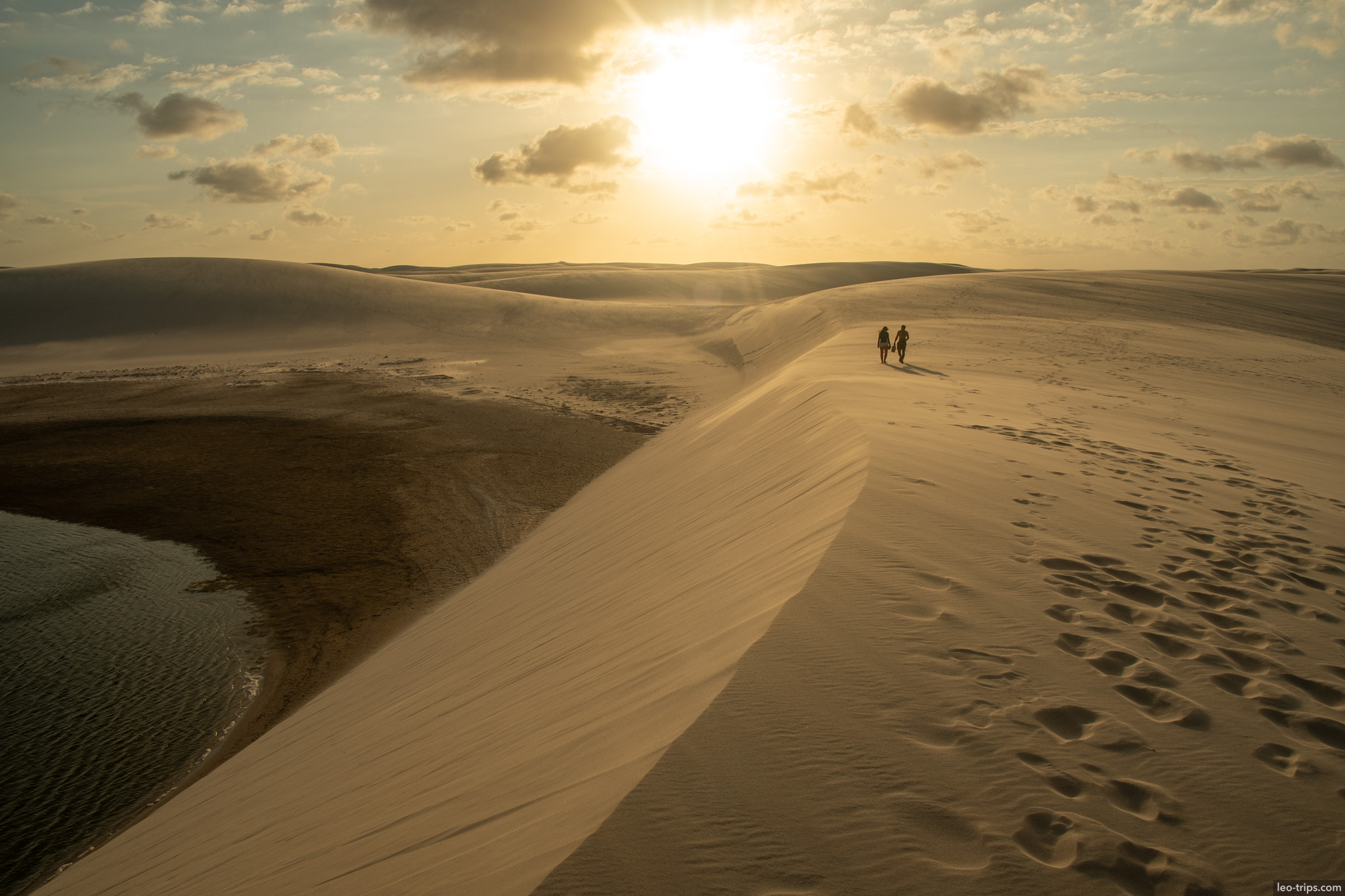 two hikers dune ridge sunset lencois lencois maranhenses