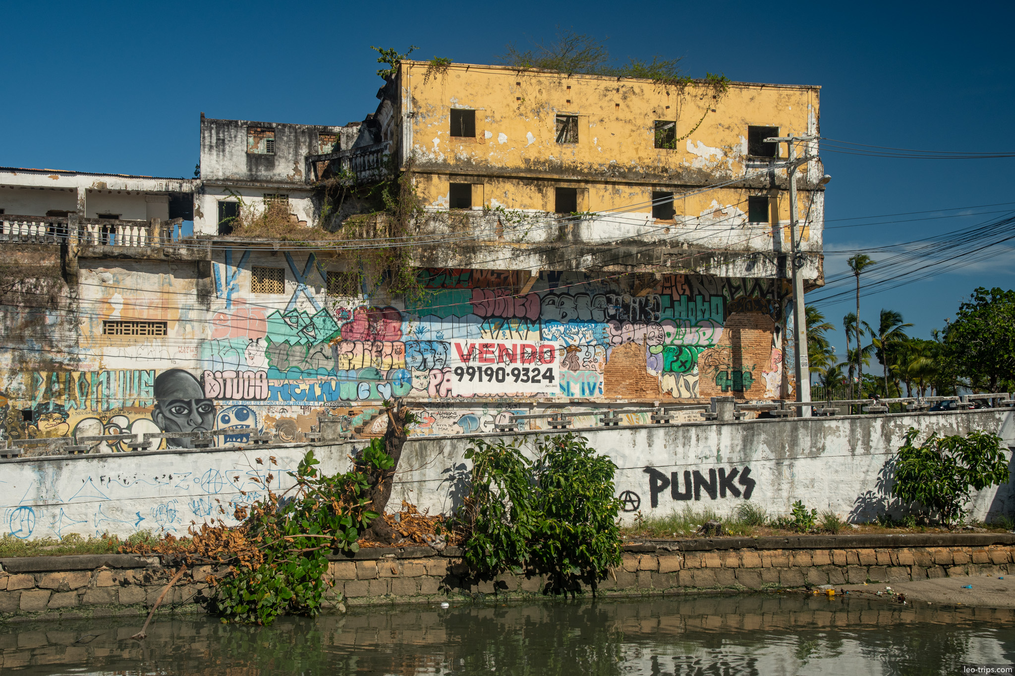 abandoned graffiti covered building by canal maceio