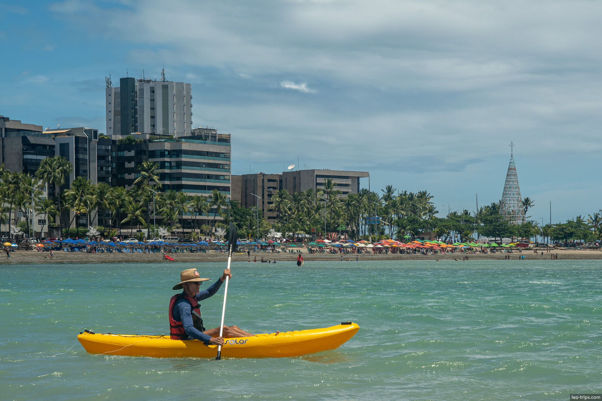 kayaker in turquoise water maceio skyline maceio