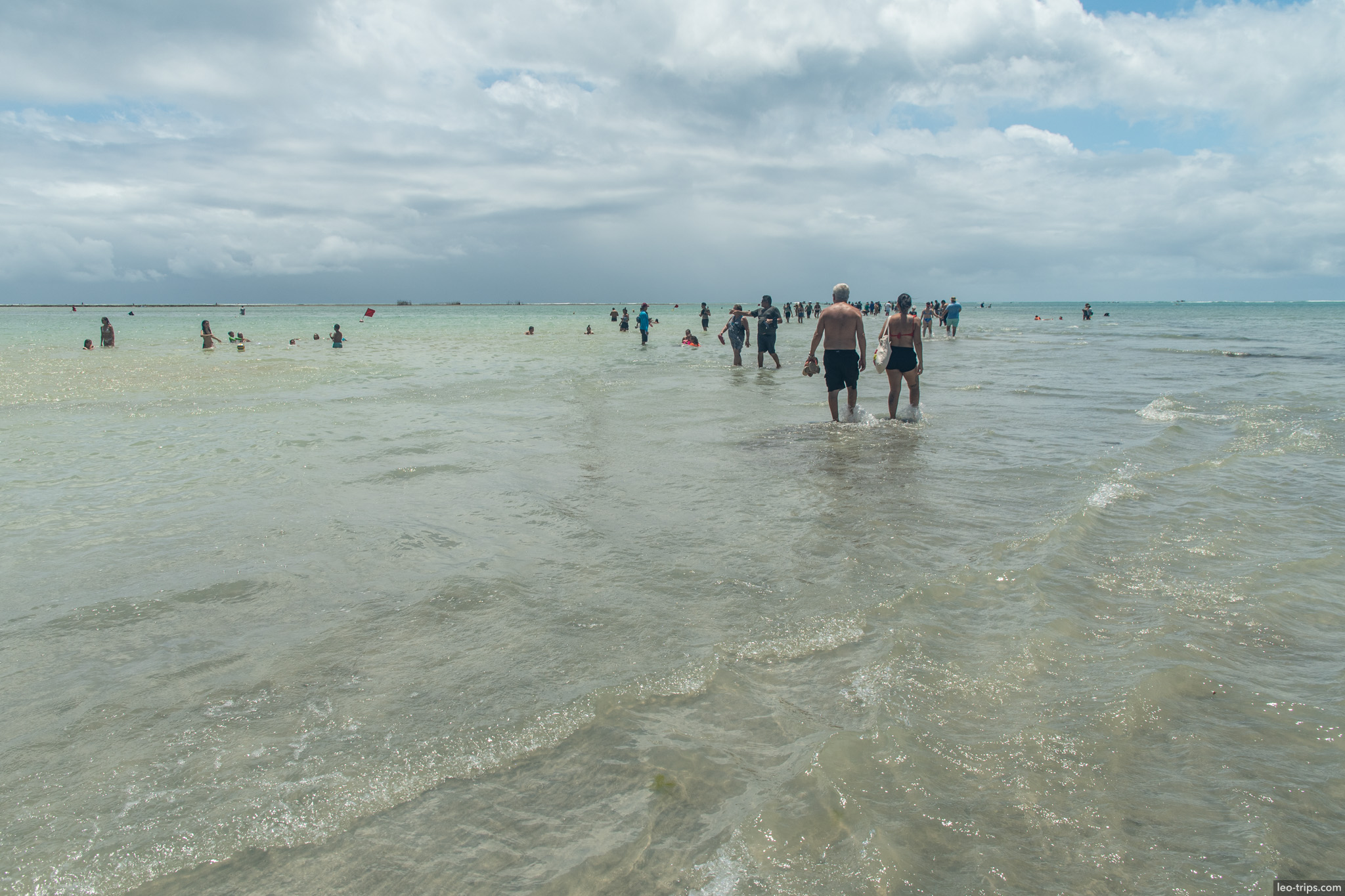 people wading to natural pools at low tide maceio