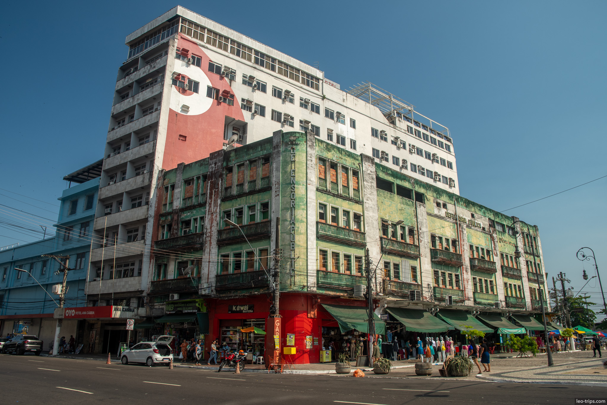 A large corner building with Art Deco influences, showing the bustling commercial side of Manaus streets