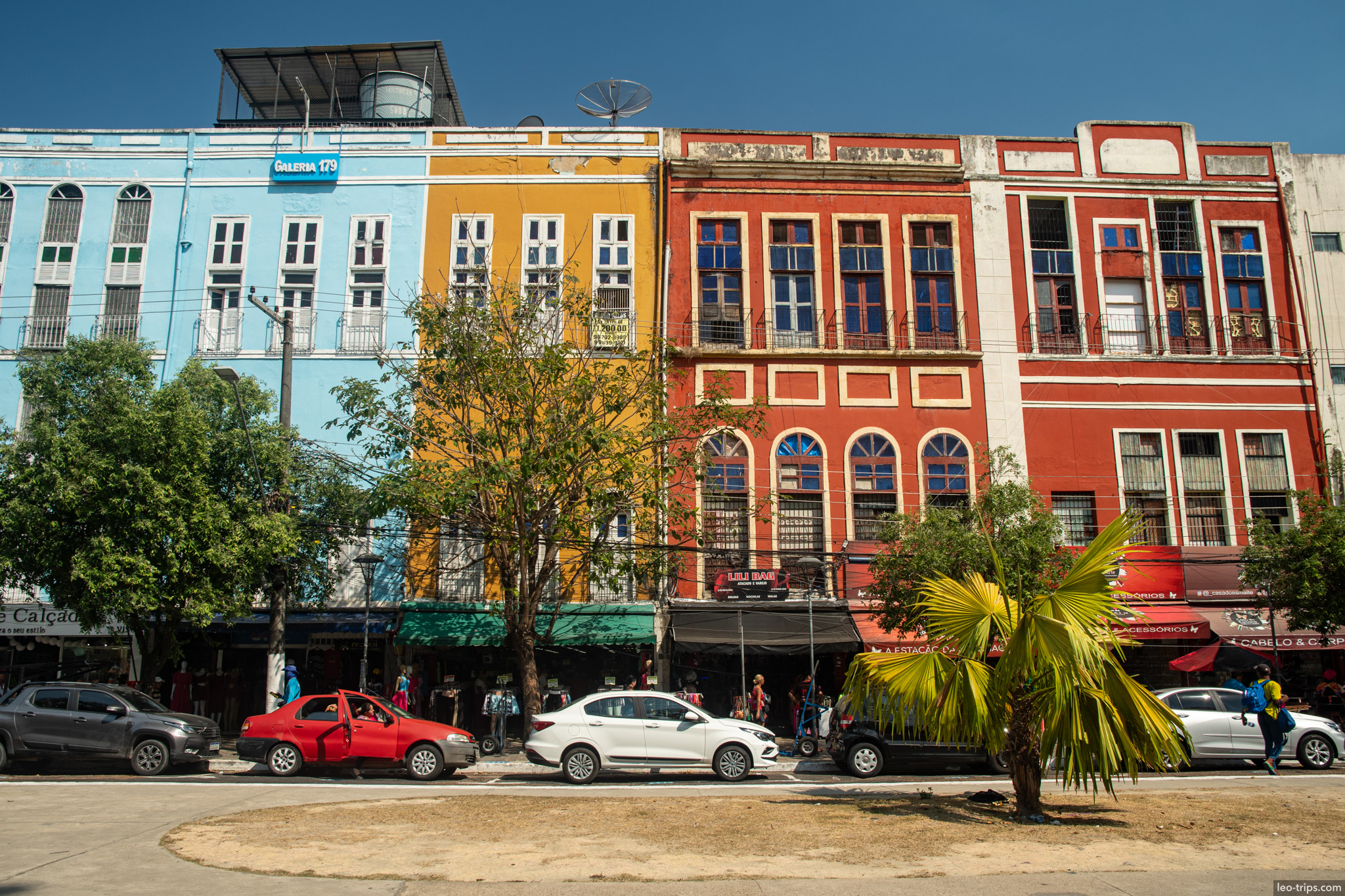 A row of charming, colorful colonial buildings with restored facades in blue, yellow, and red hues