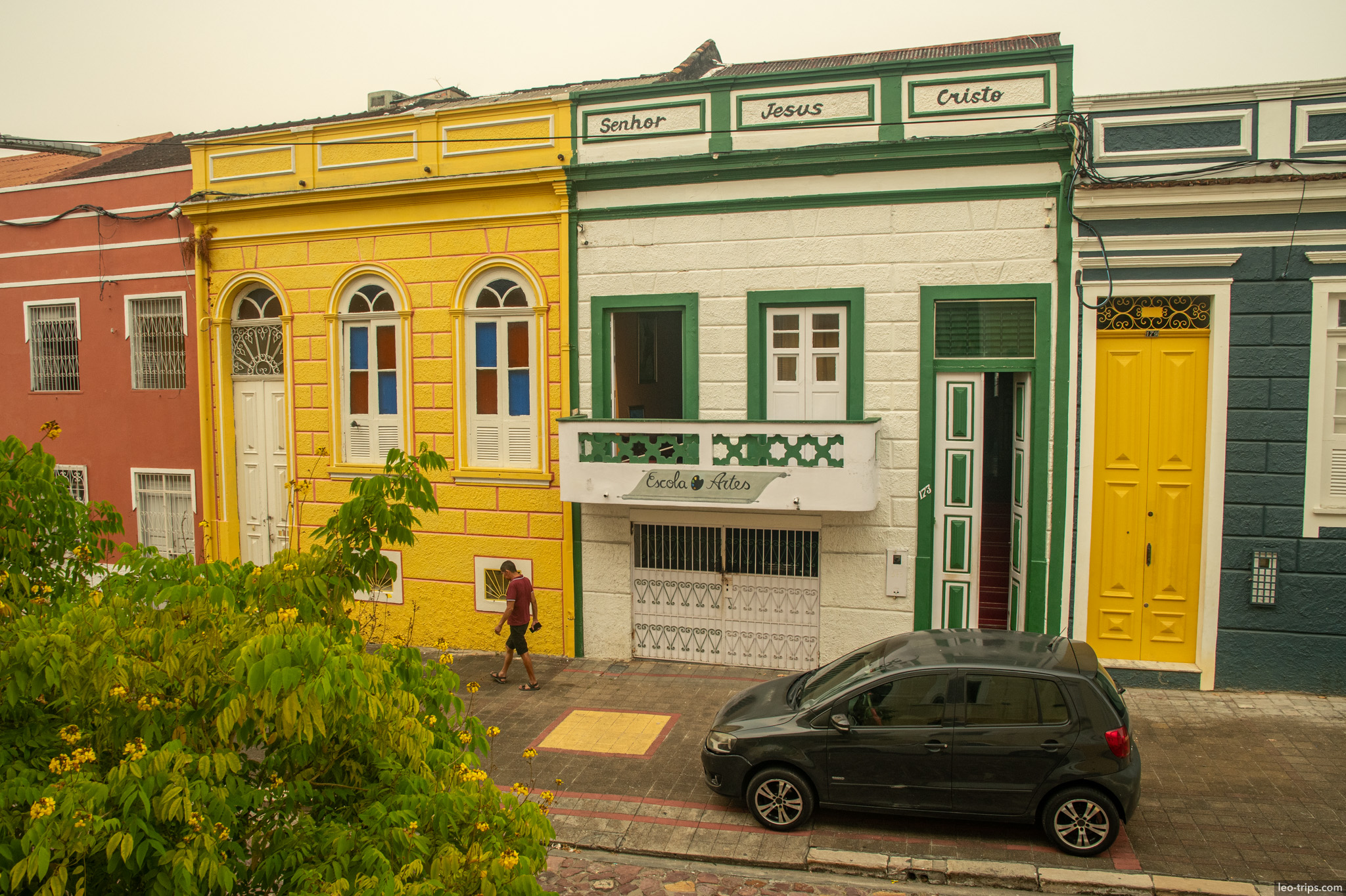 A charming row of restored colonial houses featuring bright yellow, white, and green facades in the historic district