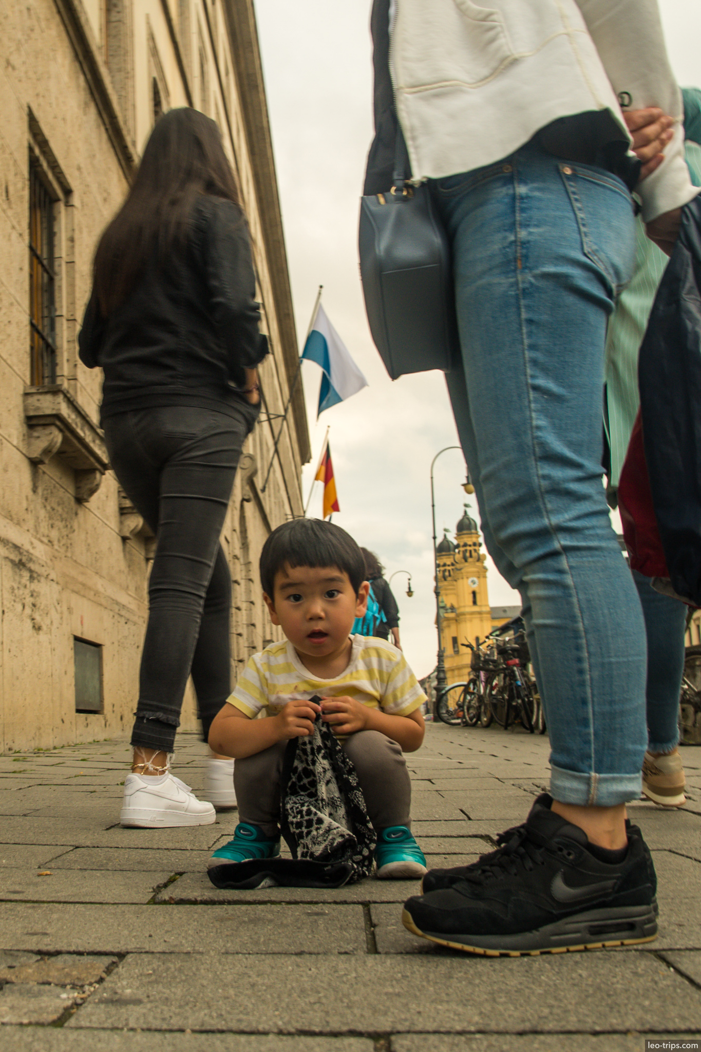 child sitting pavement tourists theatinerkirche background munich