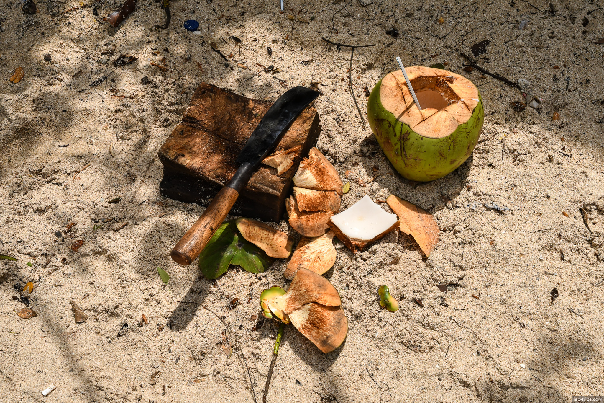 fresh coconut drink and machete on sand bali