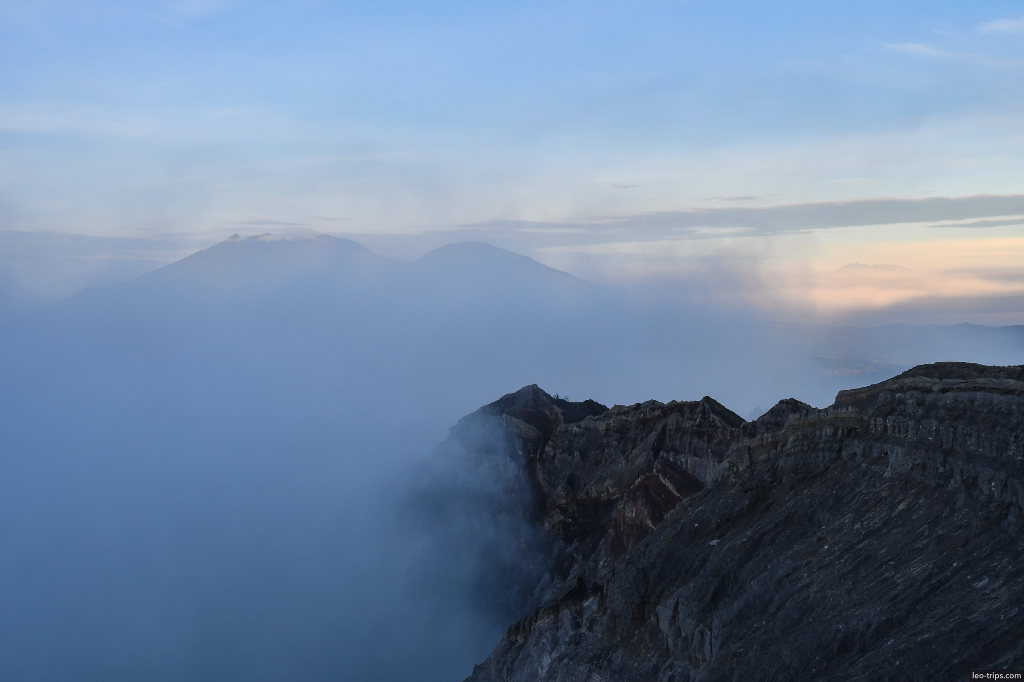 crater rim with distant volcanoes in haze ijen ijen lake