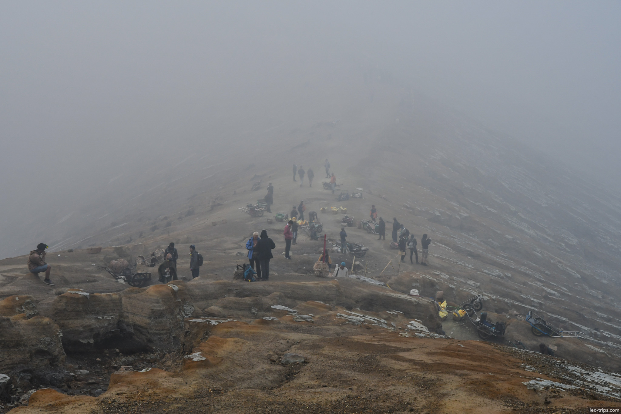 tourists and miners gathering on crater rim ijen ijen lake