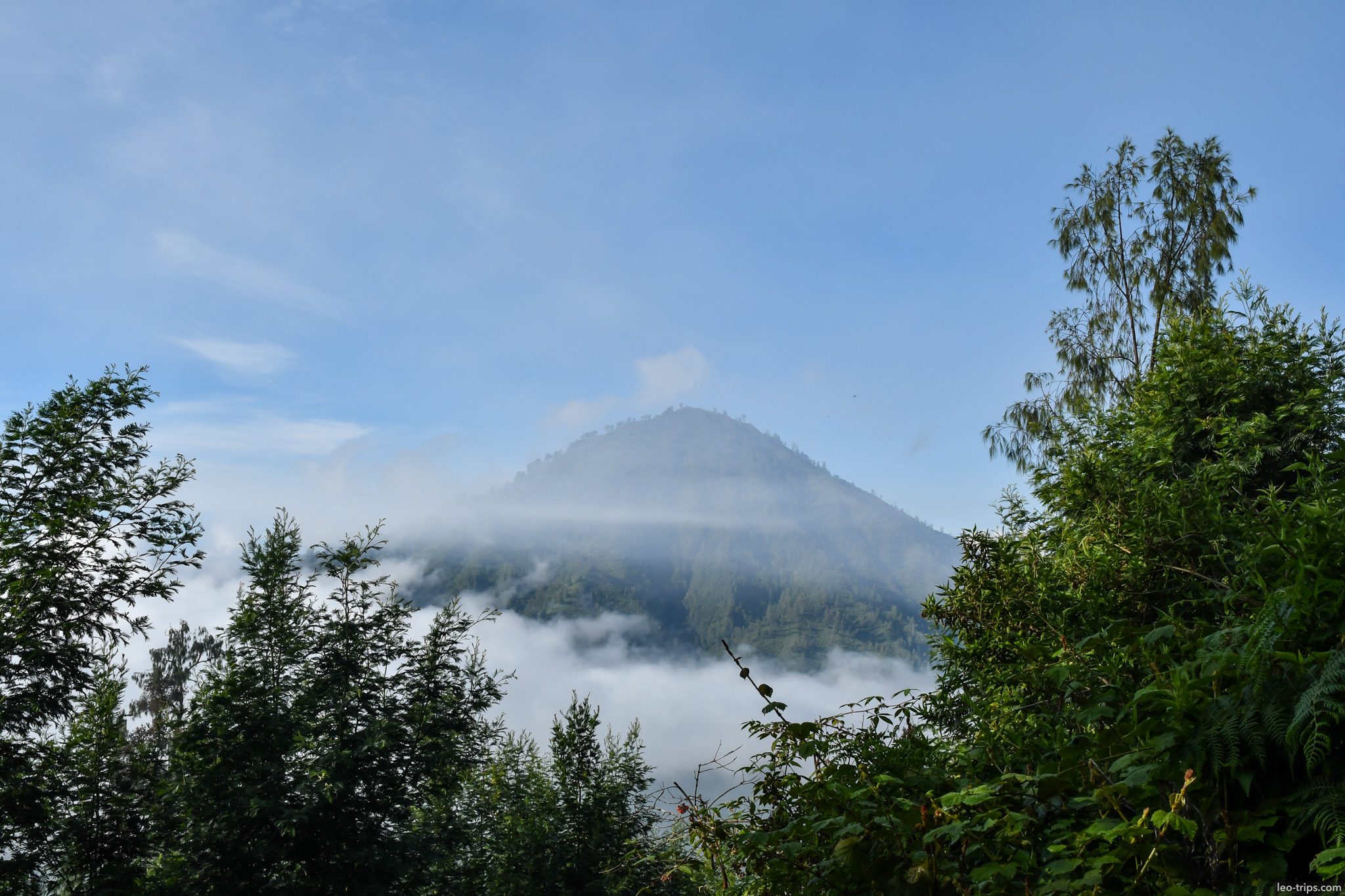 volcanic peak rising above clouds ijen ijen lake