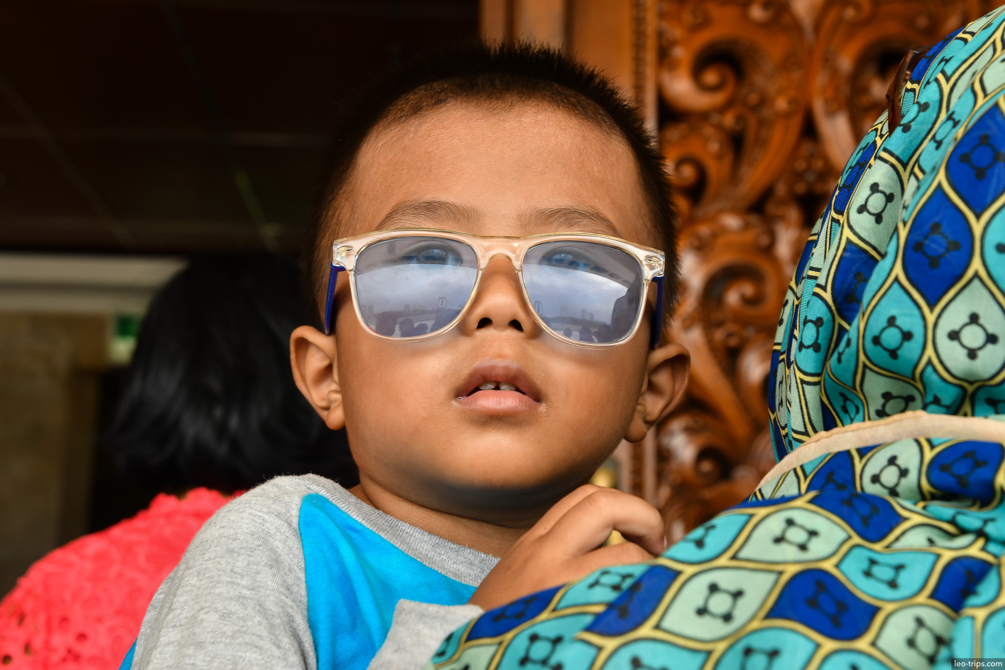 child with sunglasses carved wooden chair jakarta jakarta
