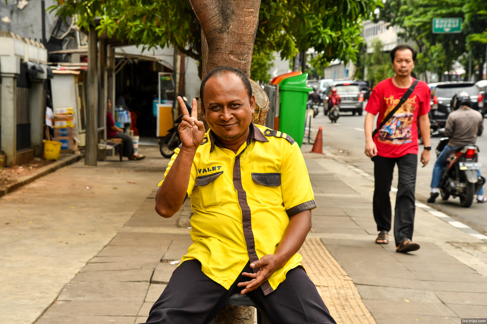 valet worker peace sign jakarta sidewalk jakarta