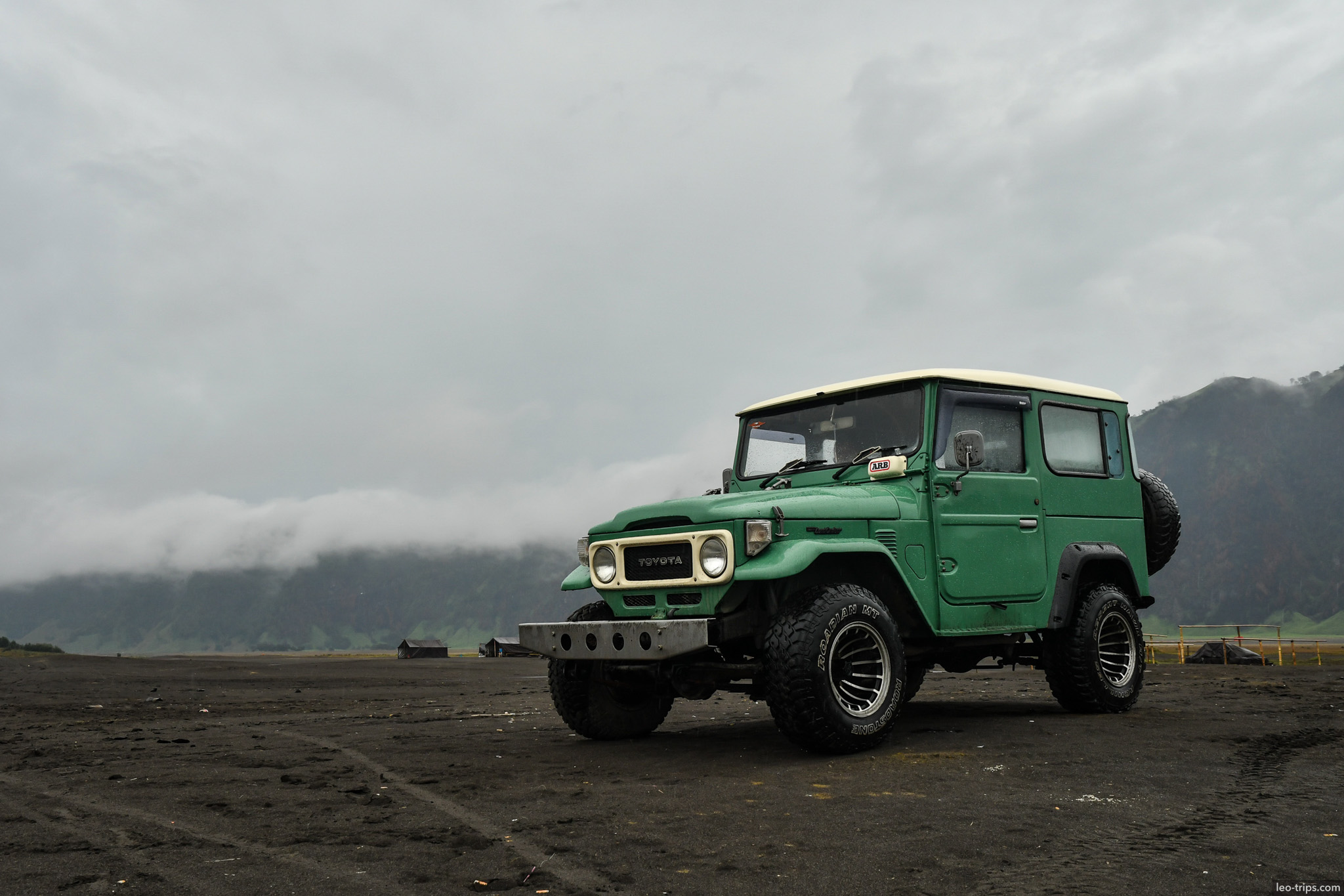 green land cruiser on volcanic sand plain mount bromo