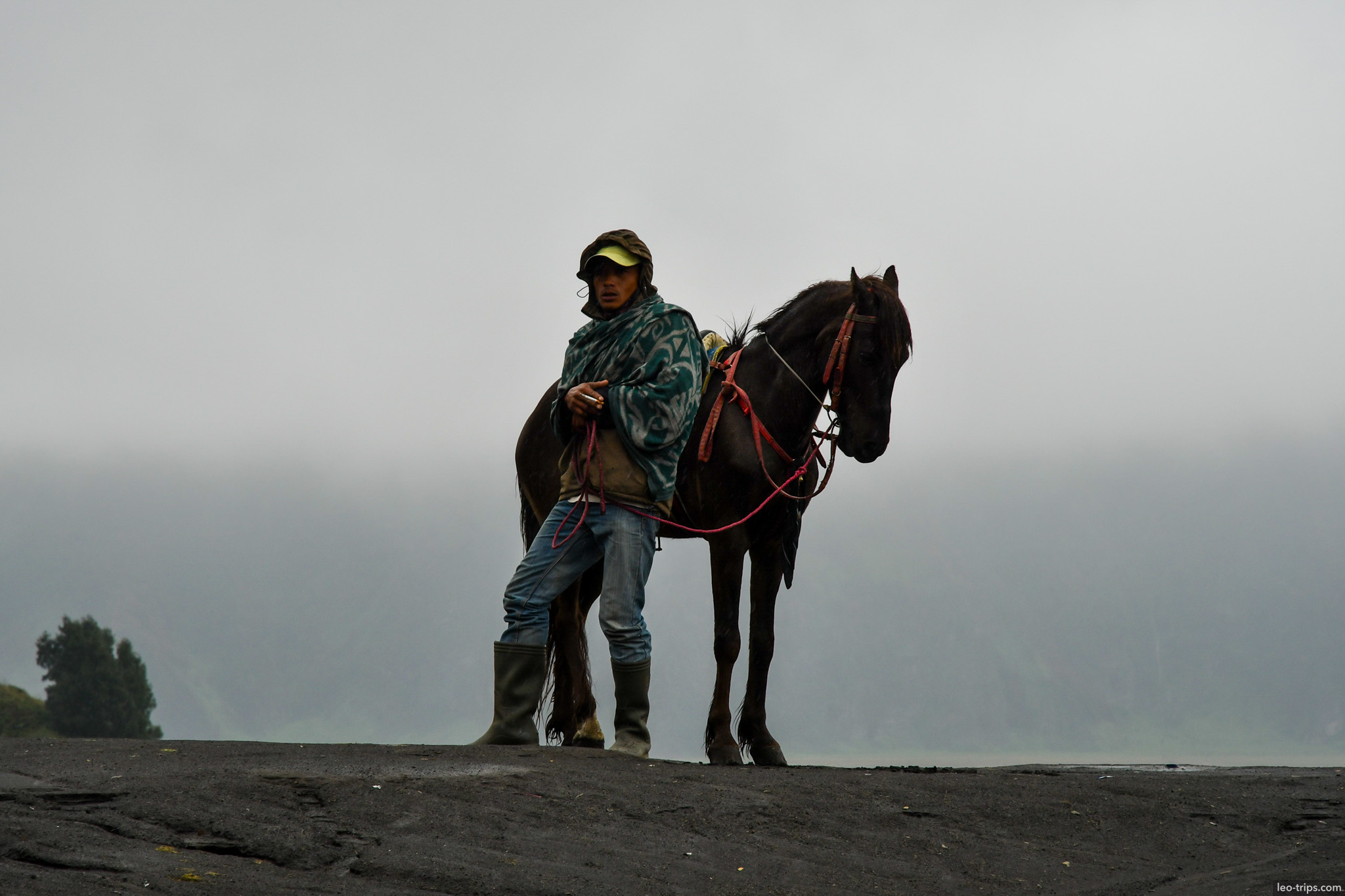 horseman standing on volcanic ash plain mount bromo