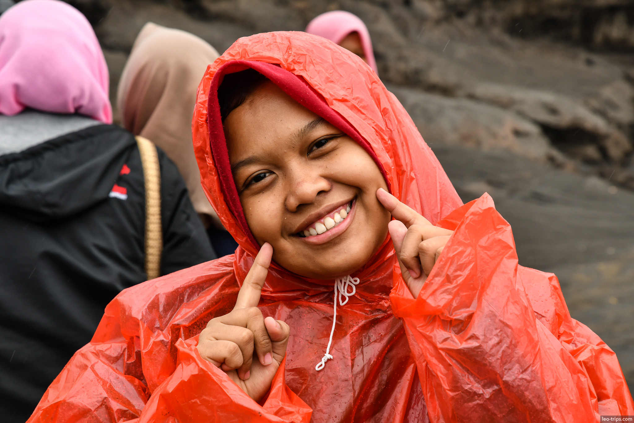 smiling girl in red raincoat bromo mount bromo