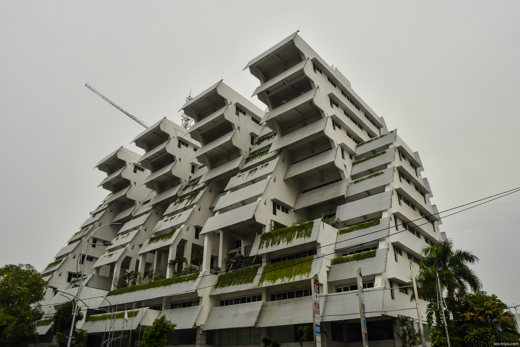 brutalist white terraced building angular balconies surabaya