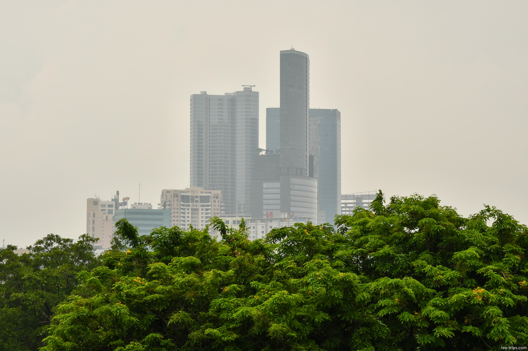 hazy skyscrapers above treetops surabaya skyline surabaya