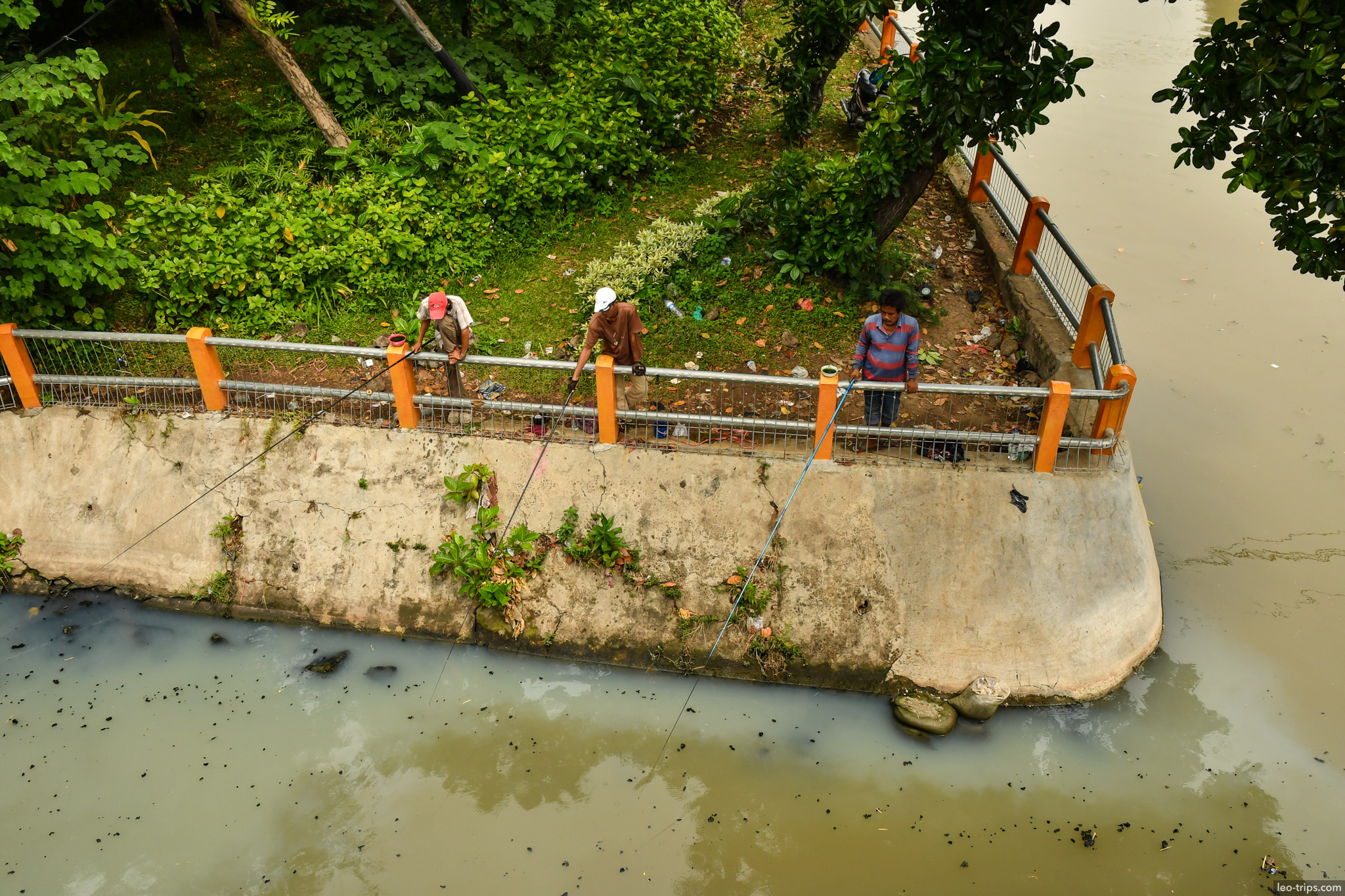 men fishing from river embankment aerial view surabaya