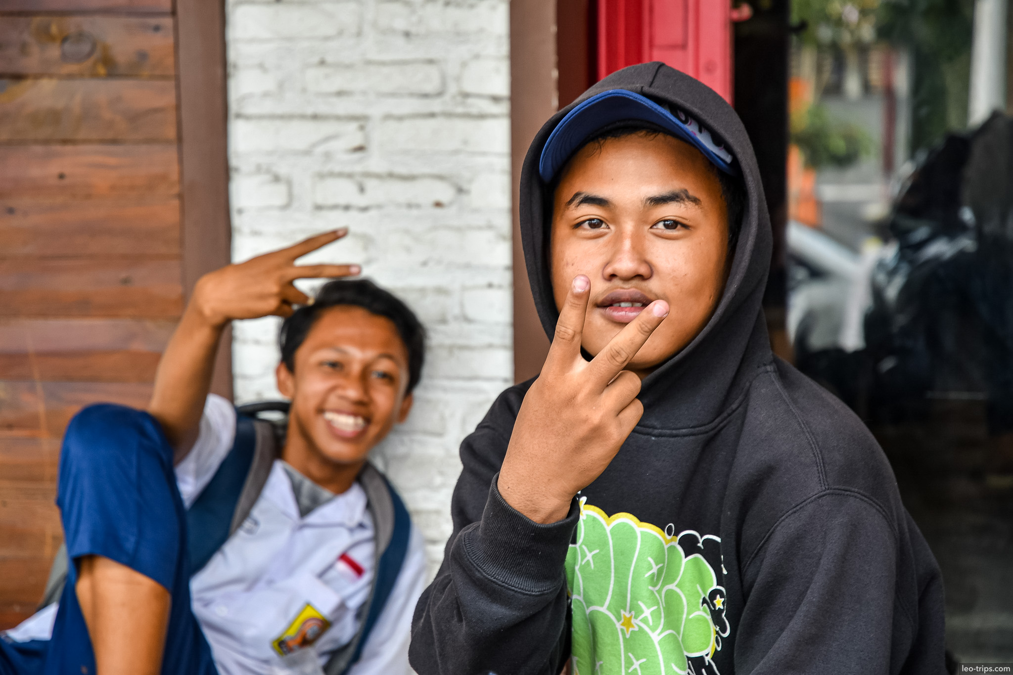 two young men posing peace signs street surabaya