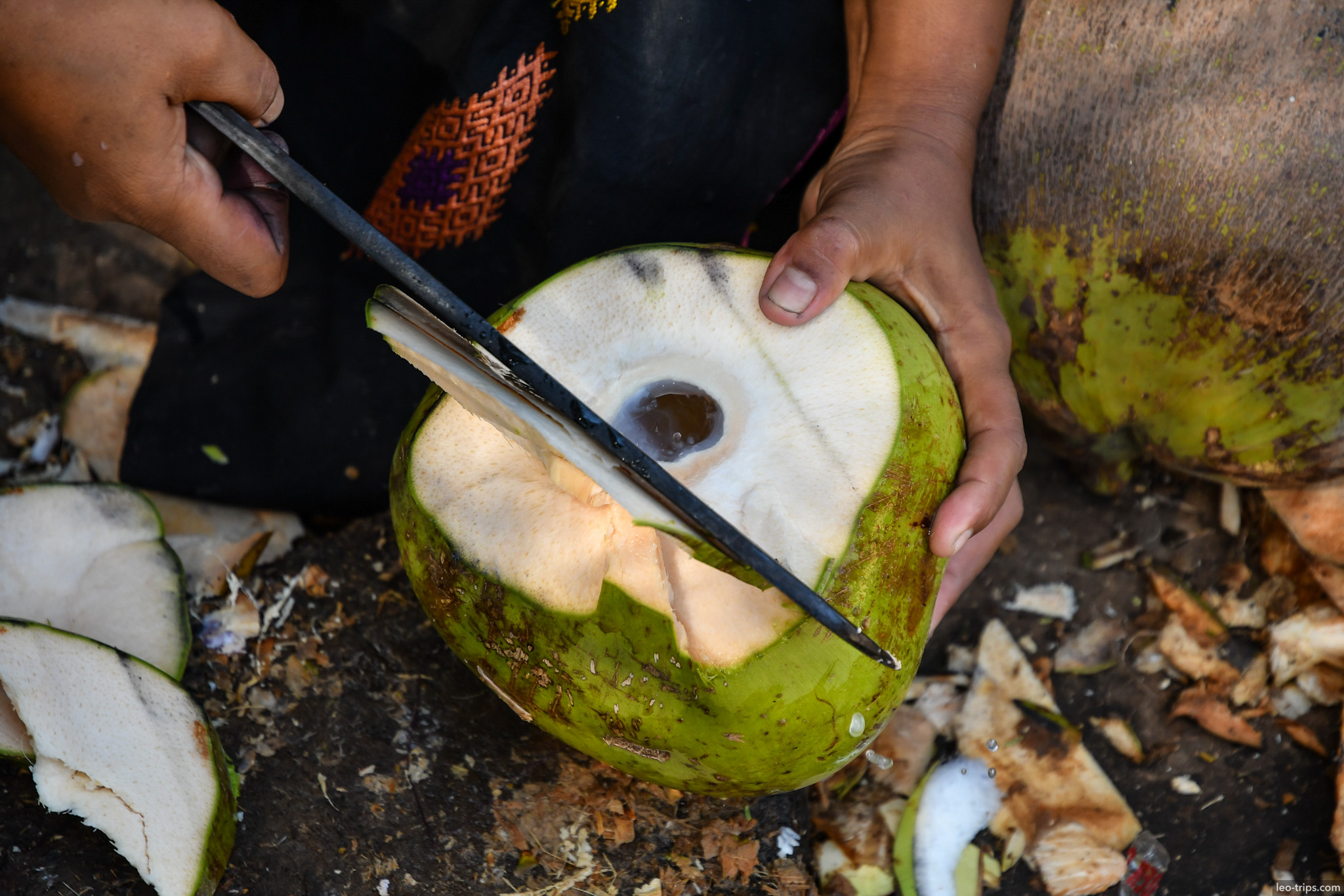 hands cutting fresh coconut with knife bagan bagan
