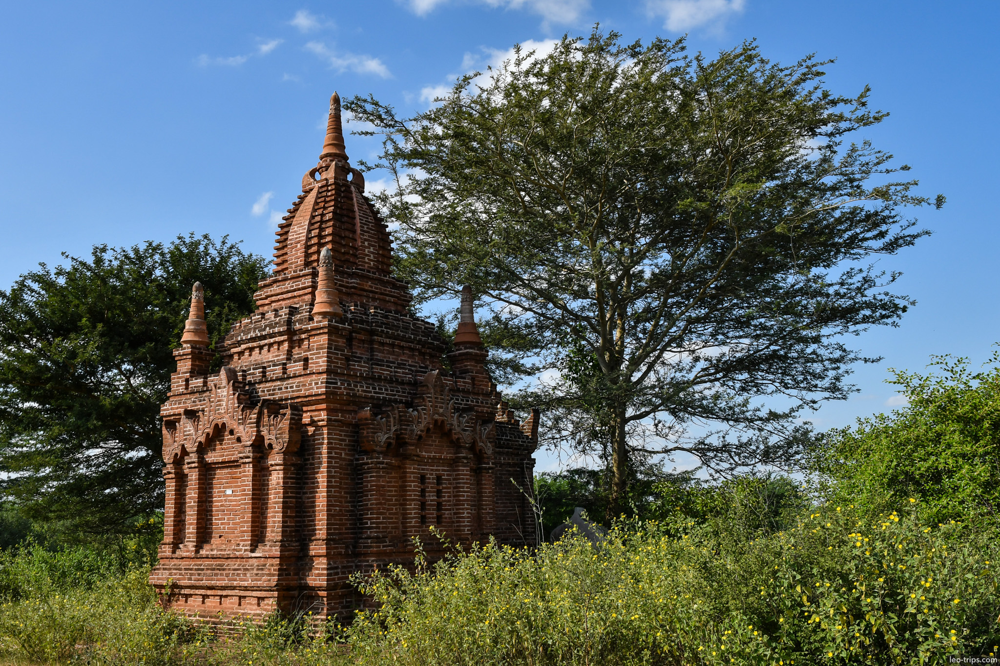 small ornate brick shrine with tree bagan bagan