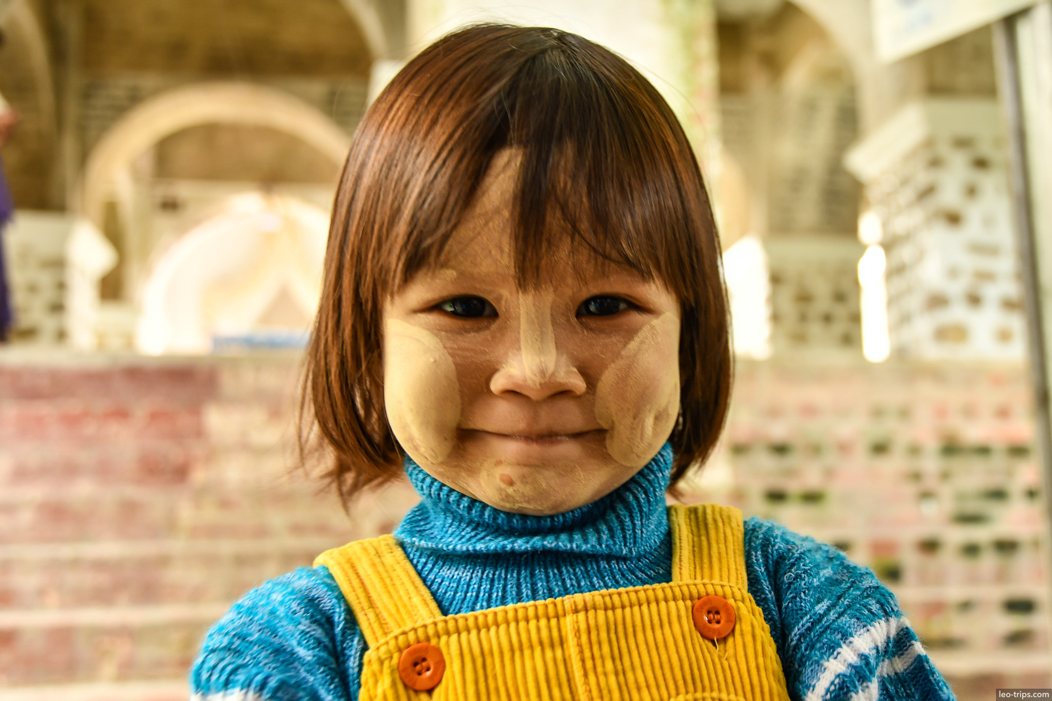 burmese girl with thanaka smiling at stupa mandalay