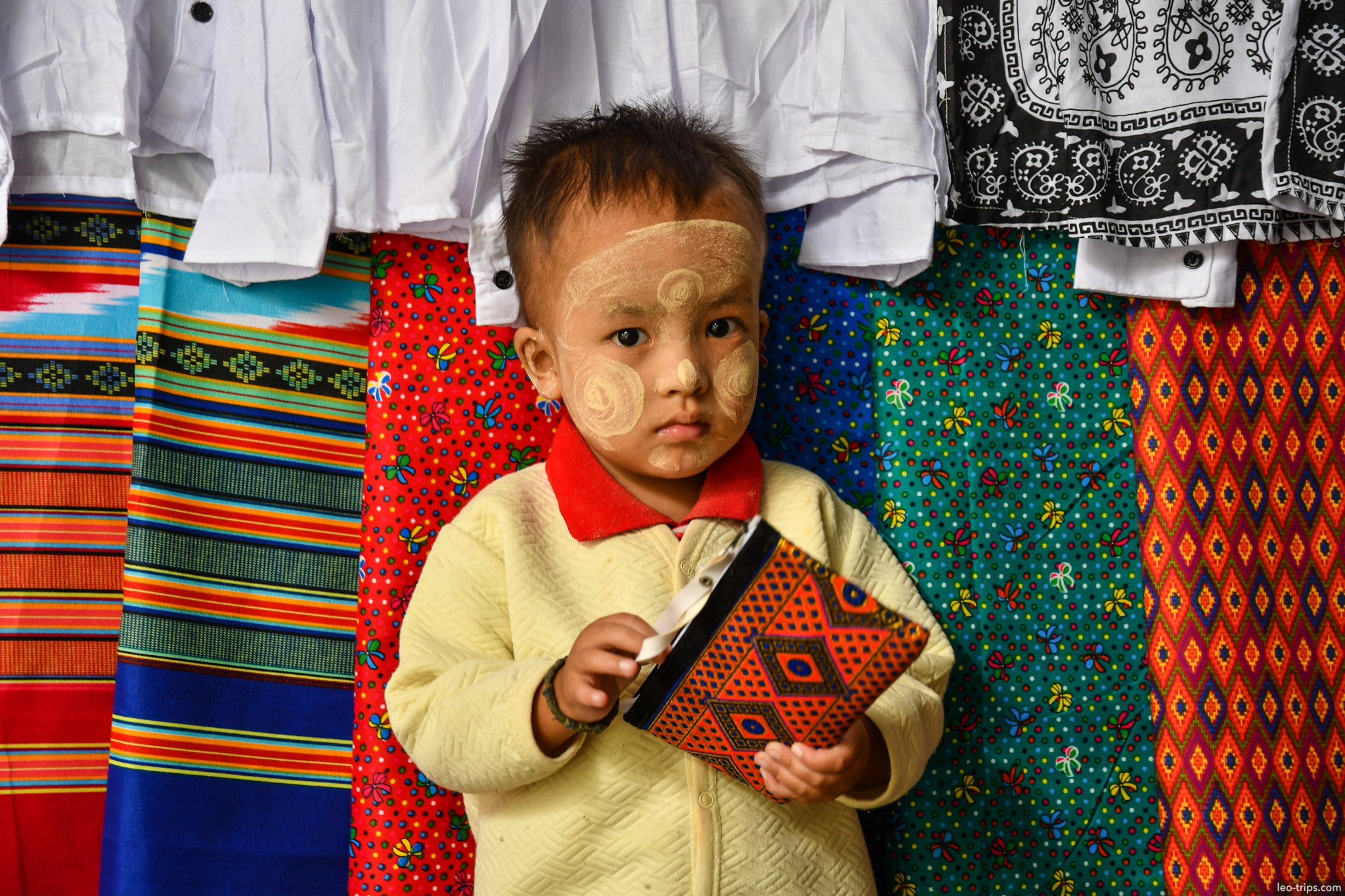burmese toddler with thanaka at textile market mandalay