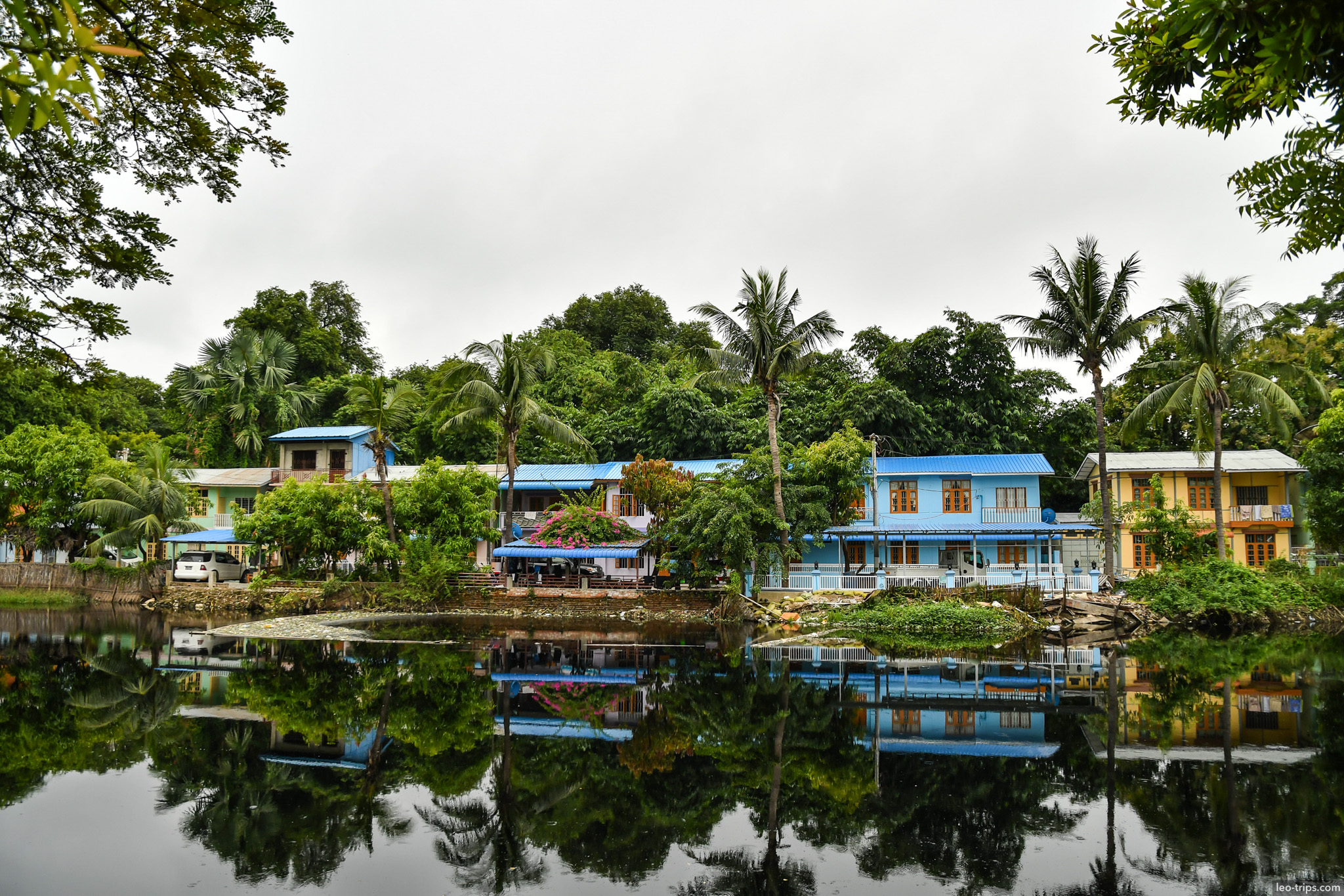tropical houses reflected in calm lake mandalay mandalay