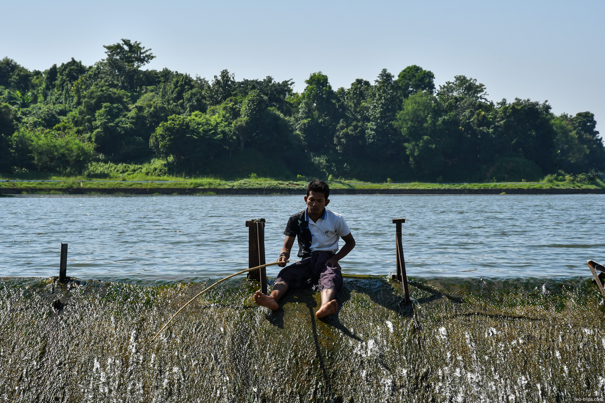 fisherman sitting on weir edge naypyidaw naypyidaw