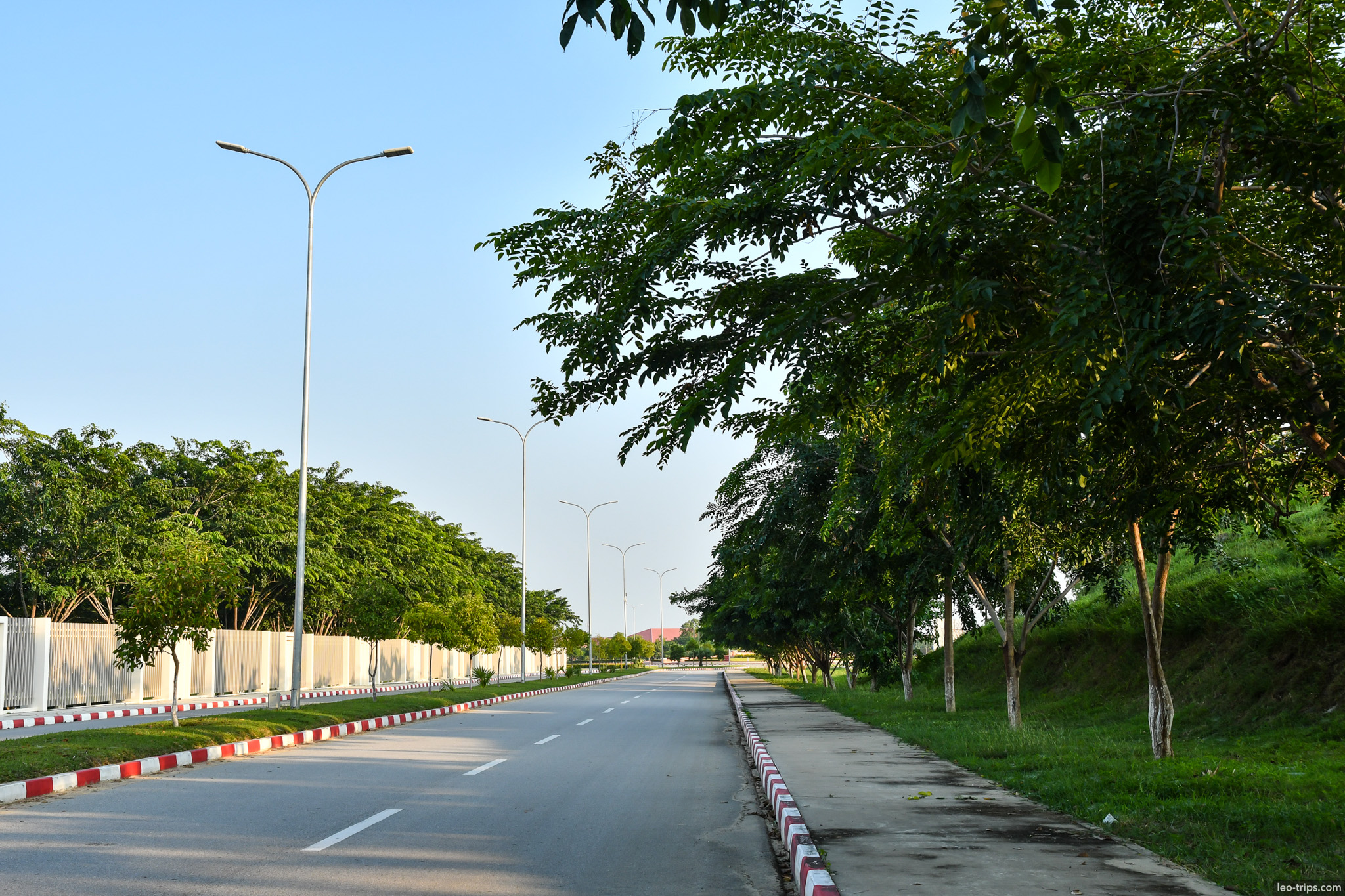 tree lined empty street with red white curbs naypyidaw naypyidaw
