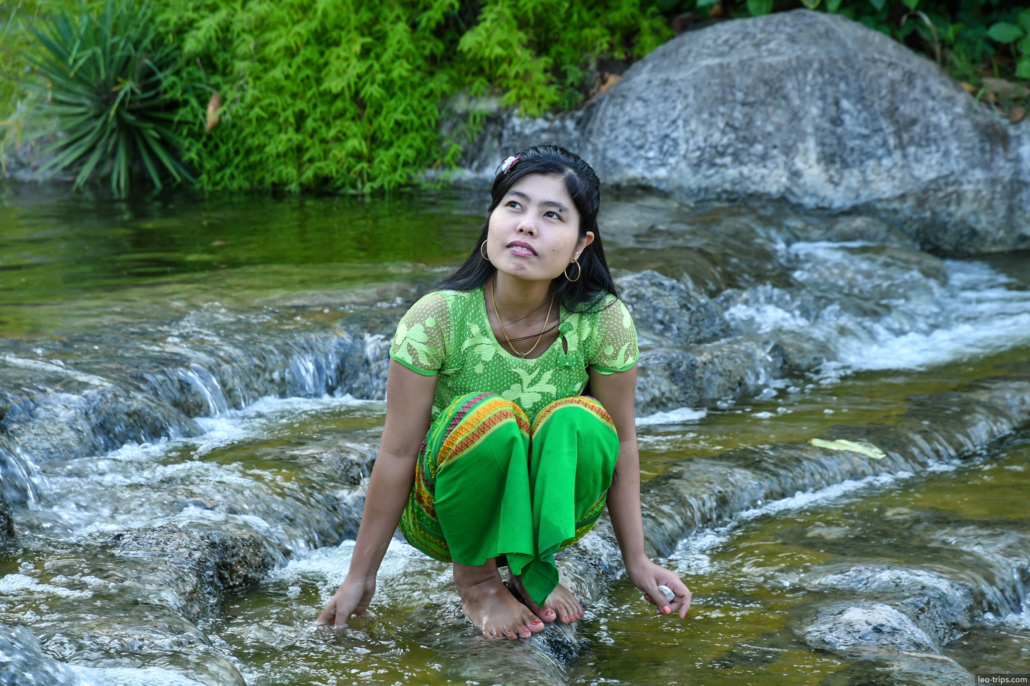 woman sitting in rocky stream naypyidaw naypyidaw
