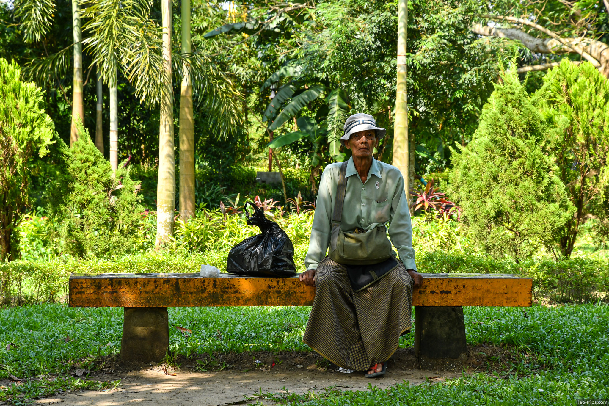 elderly woman resting on bench yangon park yangon