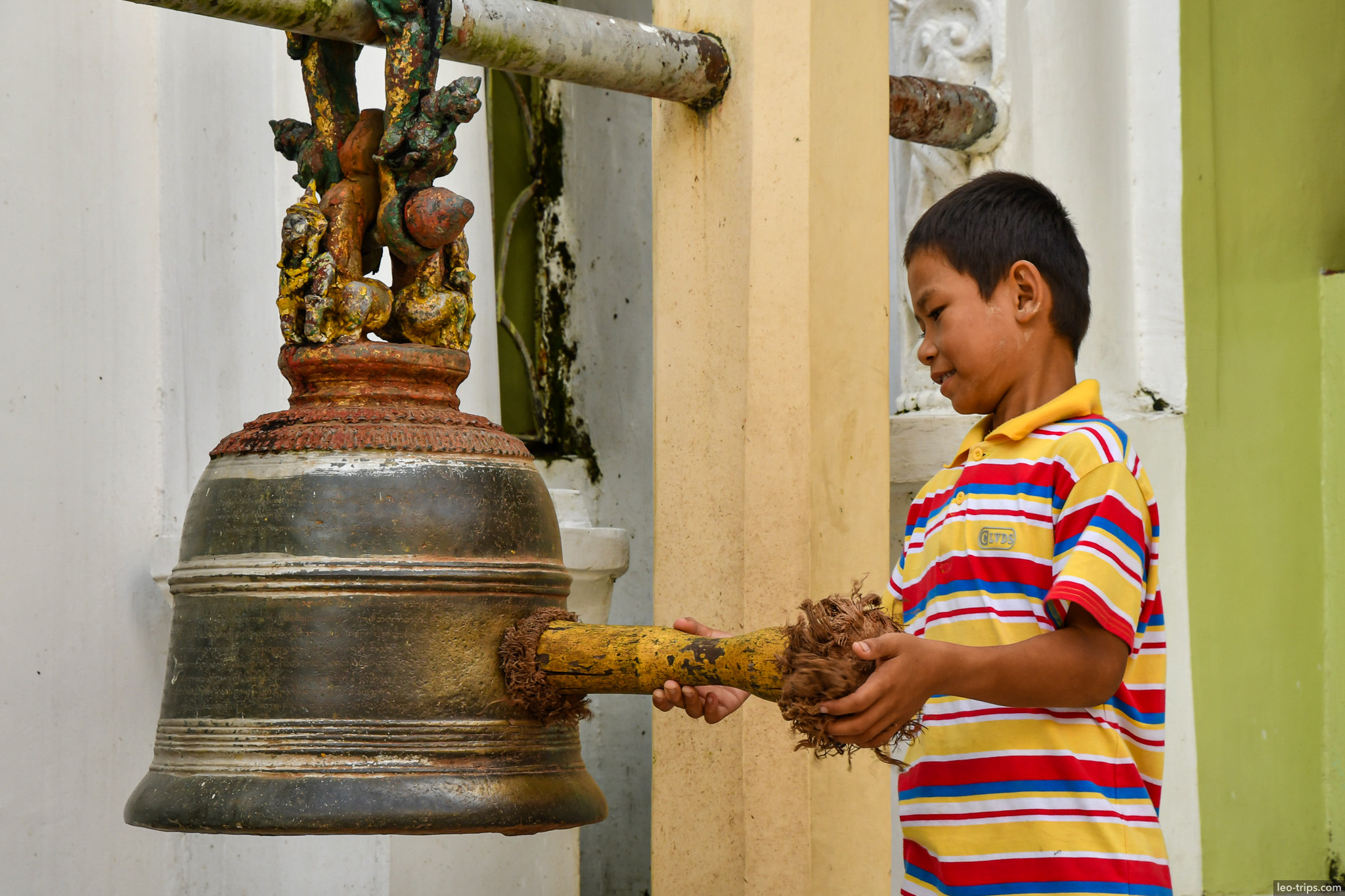 yangon shwedagon pagoda boy ringing bronze temple bell yangon