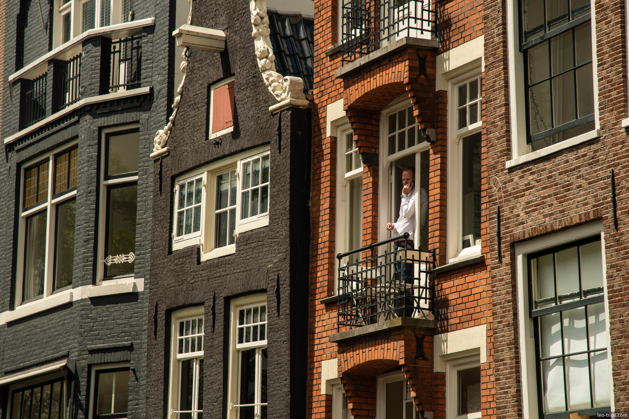 amsterdam canal house man on balcony amsterdam