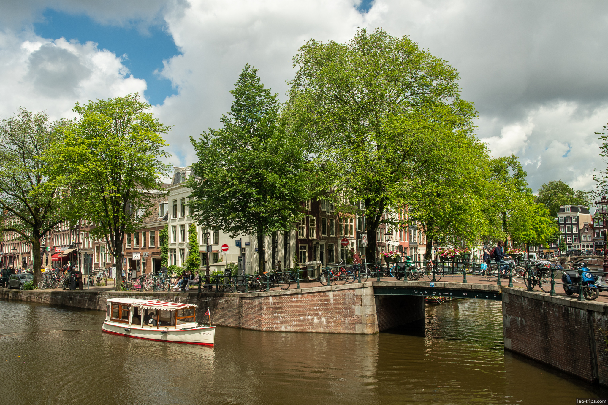amsterdam canal junction small boat cyclists bridge amsterdam