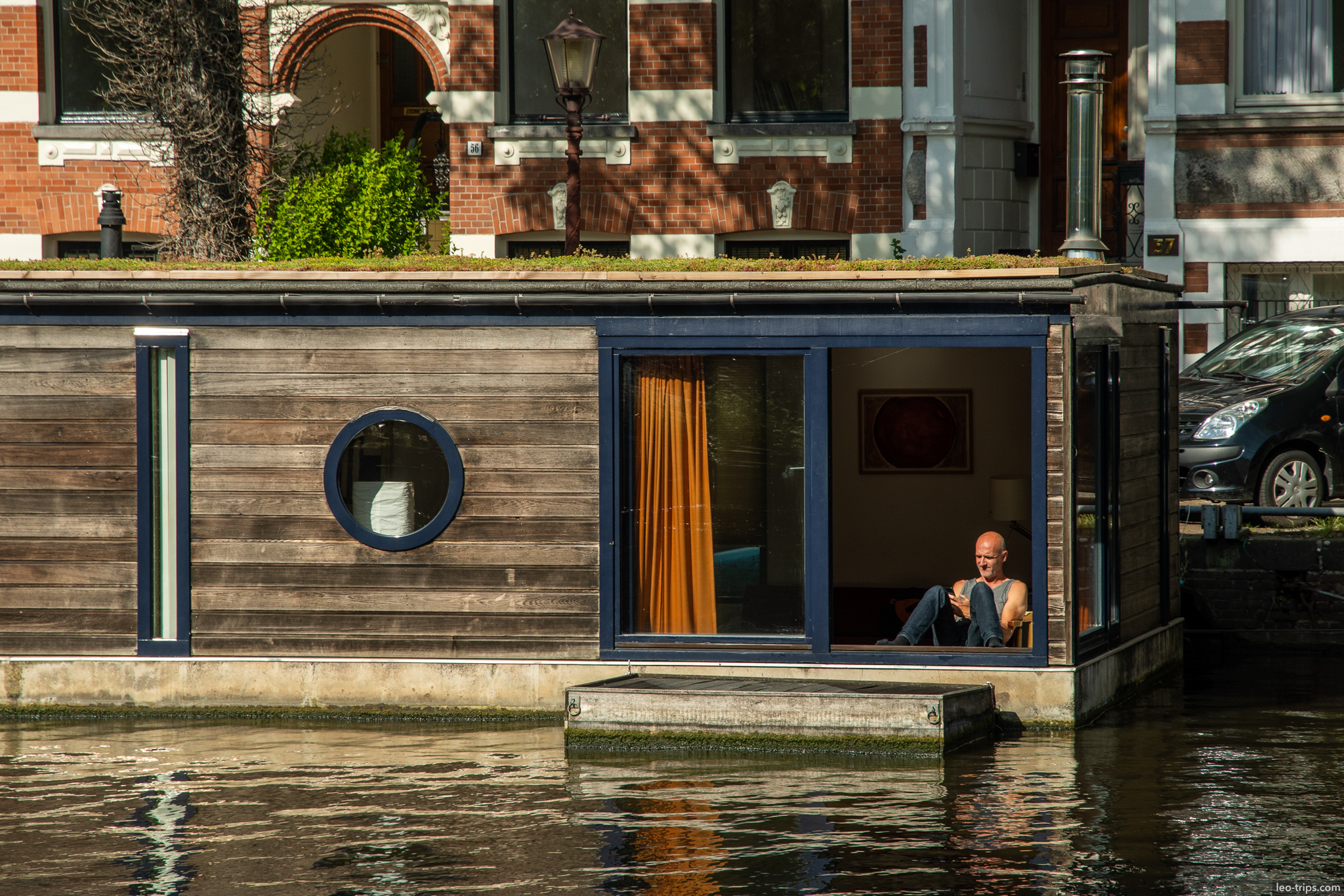 amsterdam houseboat man relaxing on canal amsterdam