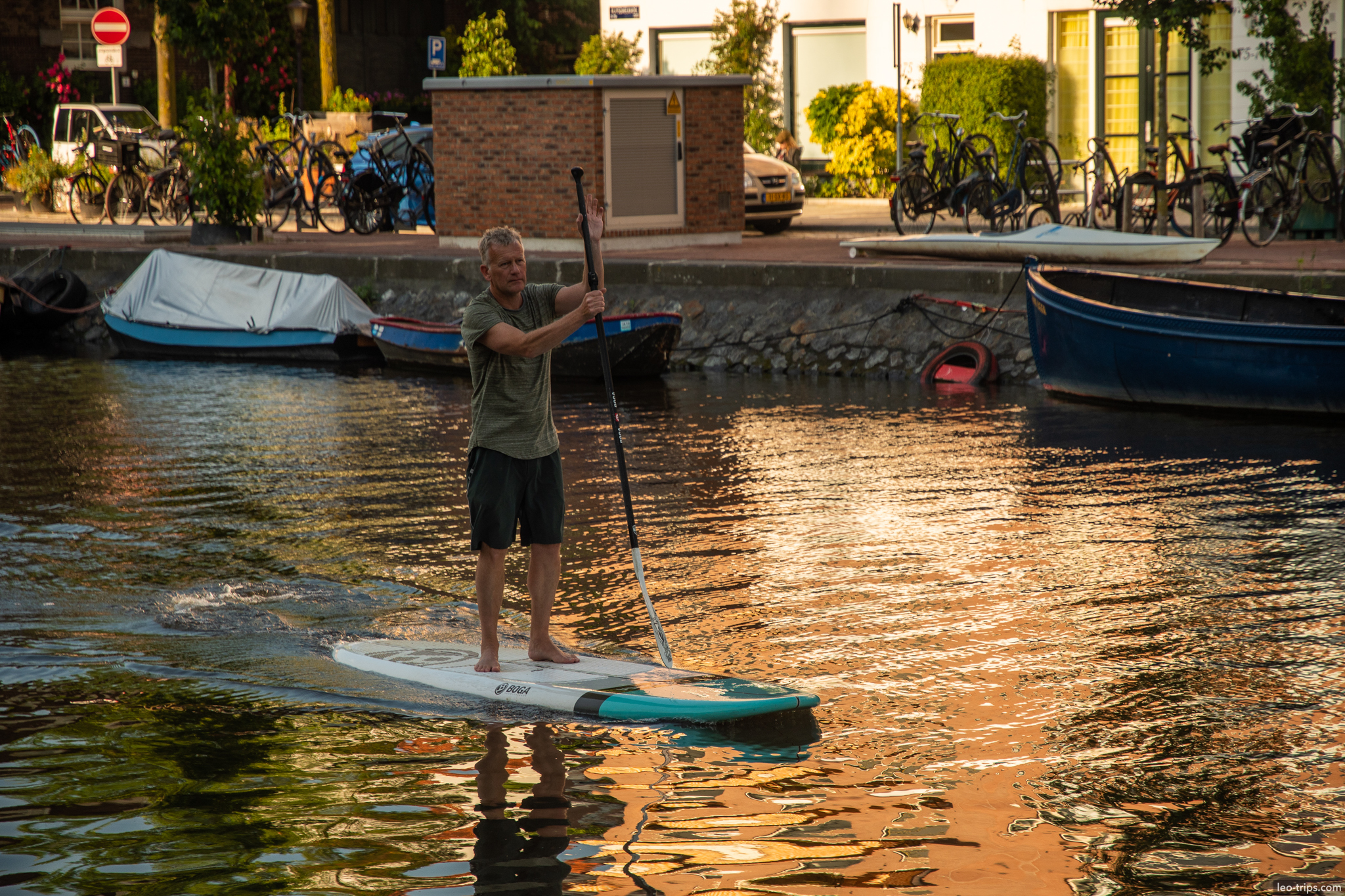 man stand up paddleboarding on amsterdam canal amsterdam