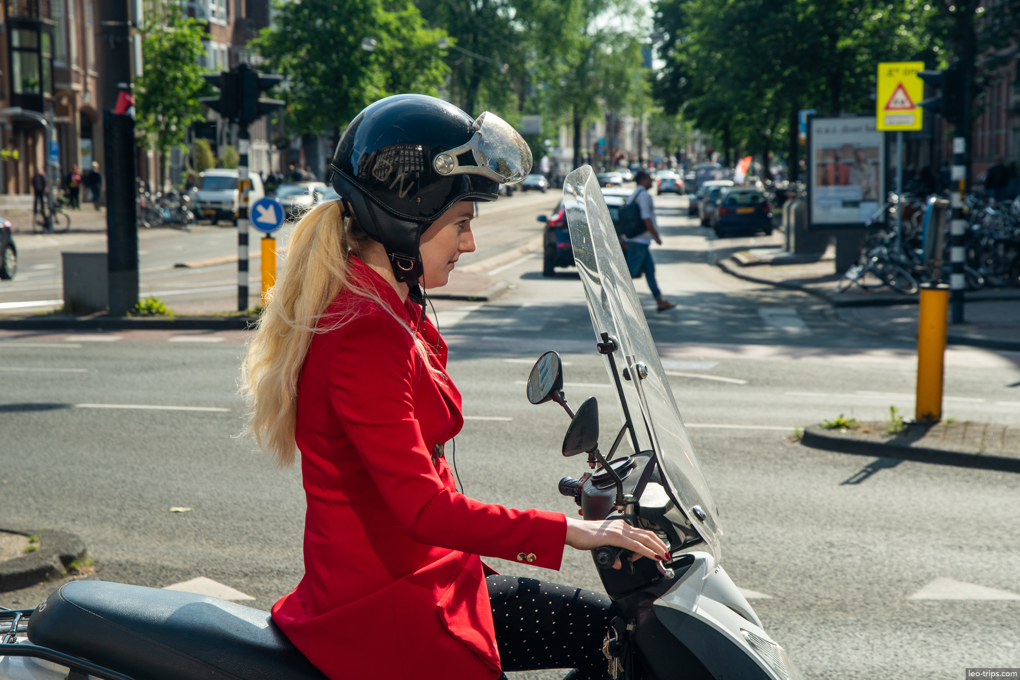 woman in red jacket riding scooter amsterdam amsterdam