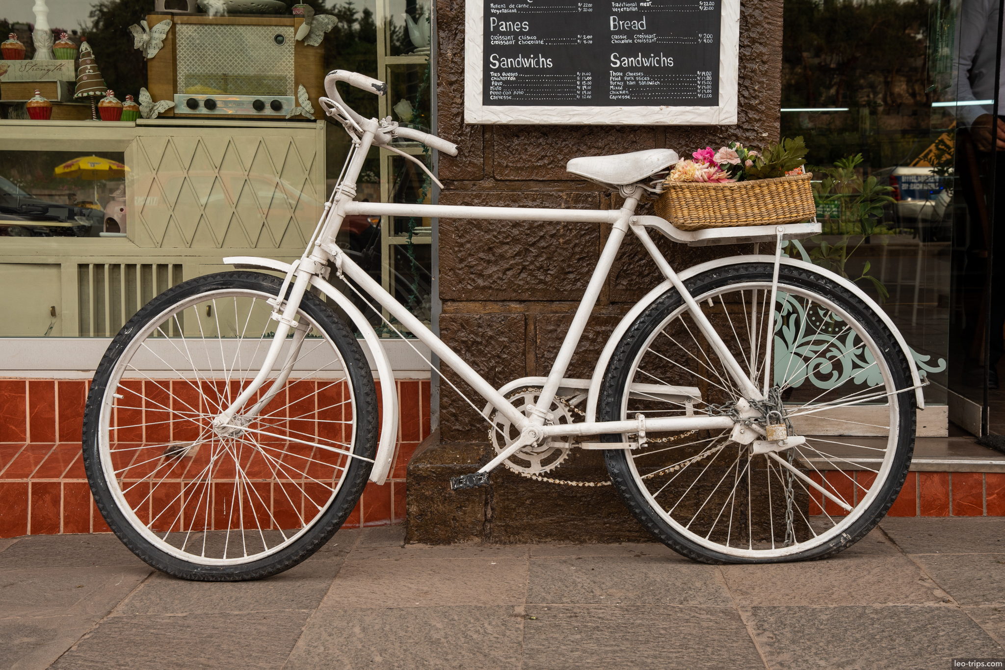 white bicycle with basket outside bakery cusco