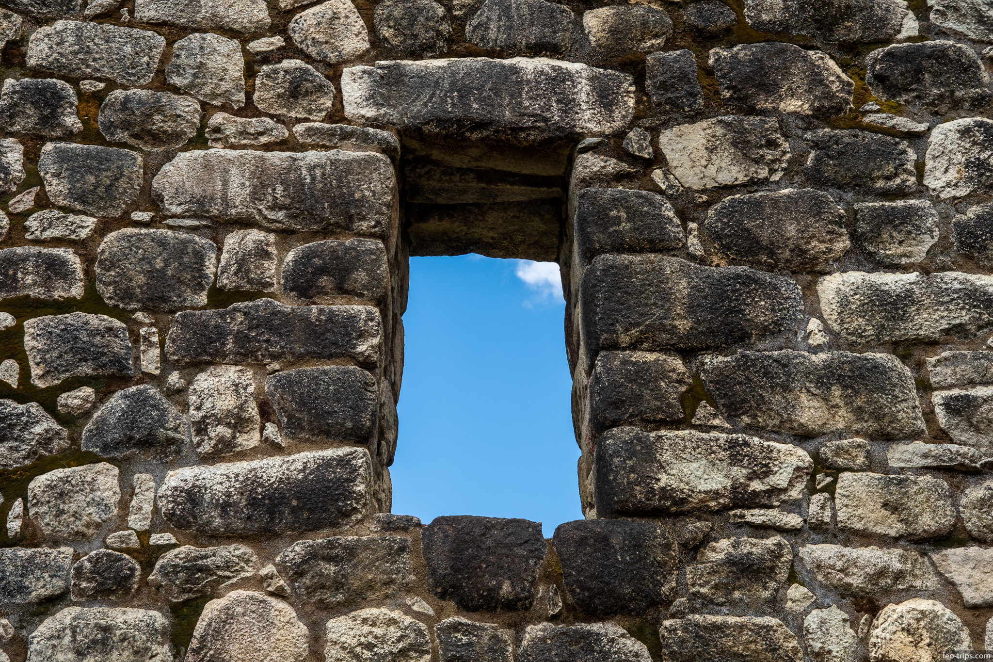 inca trapezoidal window stone wall blue sky machu picchu