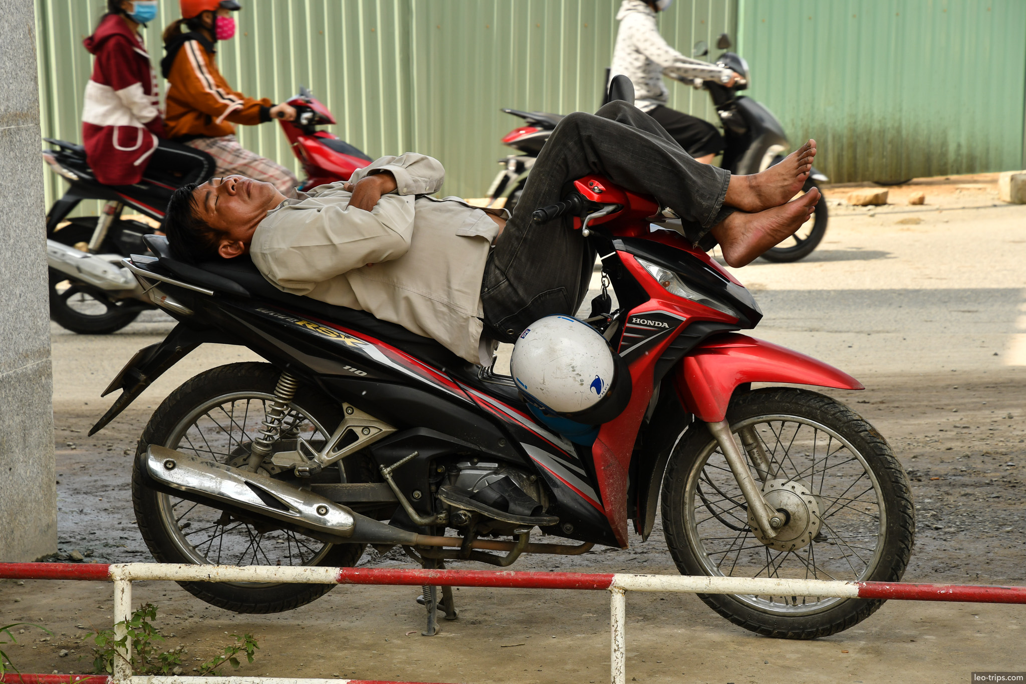 vietnamese man sleeping on motorcycle street da nang