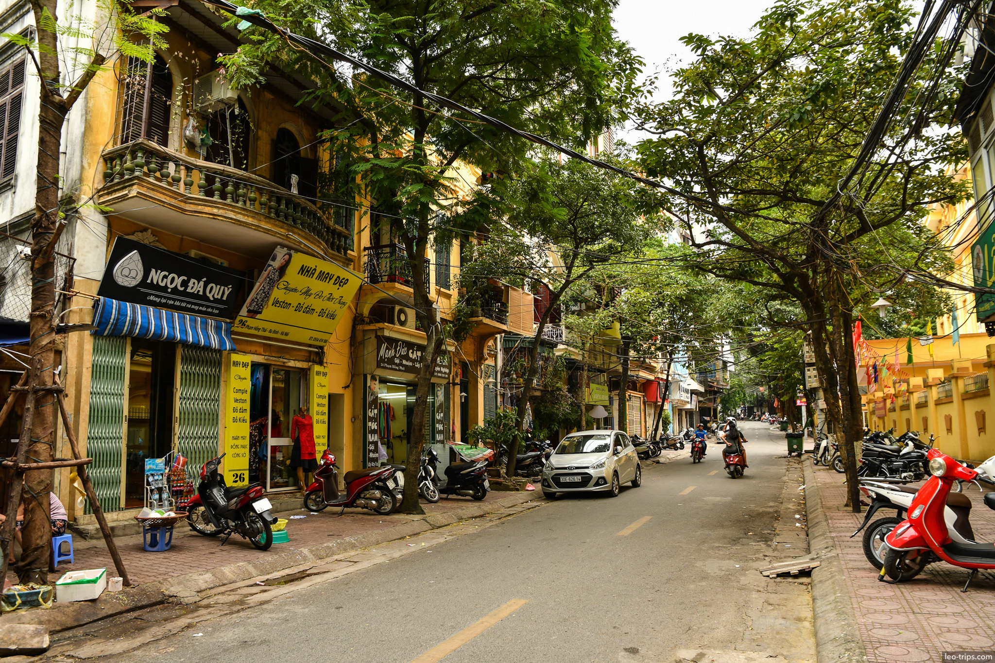 tree lined street shops motorbikes hanoi old quarter hanoi