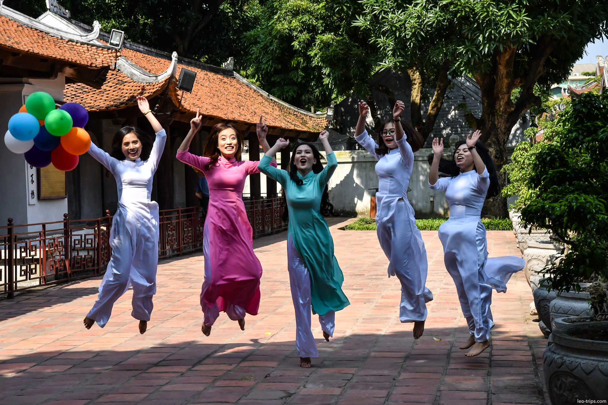 women ao dai jumping temple of literature hanoi hanoi